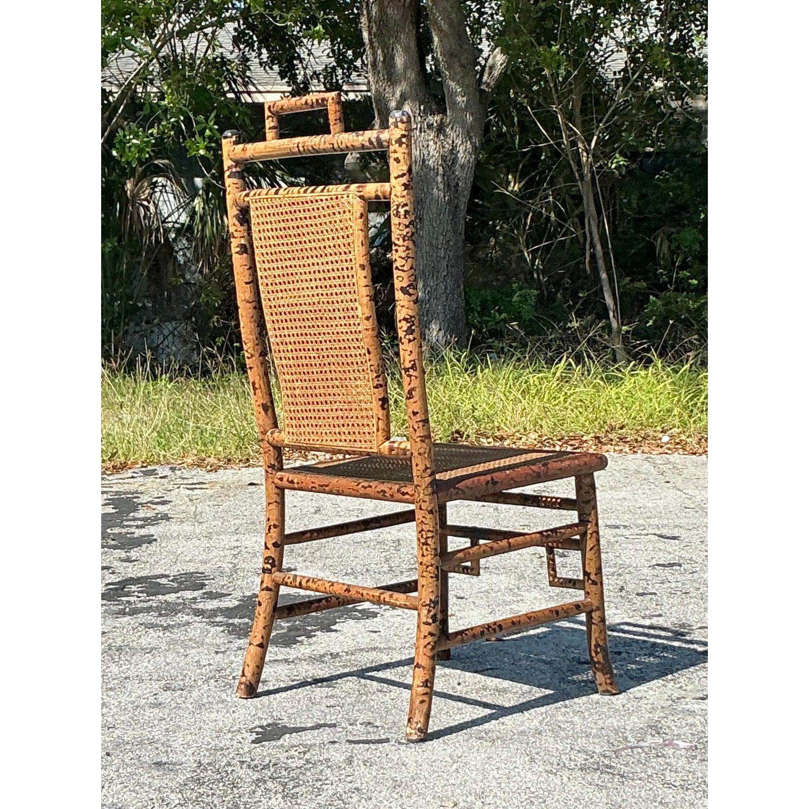 This striking vintage tortoise bamboo chair blends natural elegance with coastal charm, featuring a beautifully woven cane backrest and seat for an airy, lightweight feel. Its tall, sculptural frame, intricate bamboo detailing, and pagoda-style top