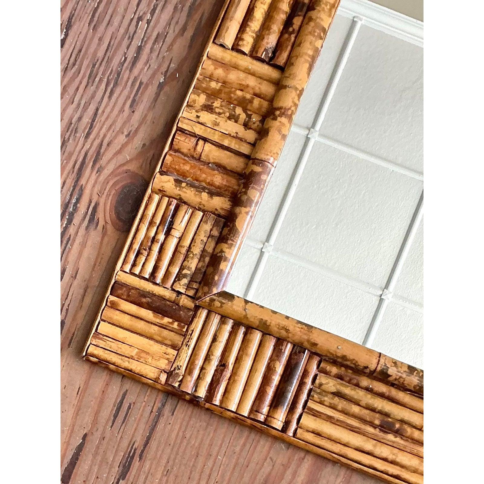 Fantastico esempio di artigianato bohémien degli anni '70, questo specchio da parete vintage è una celebrazione della texture naturale e del design organico. Meticolosamente costruita in vero bambù, la struttura sostanziale presenta una sofisticata