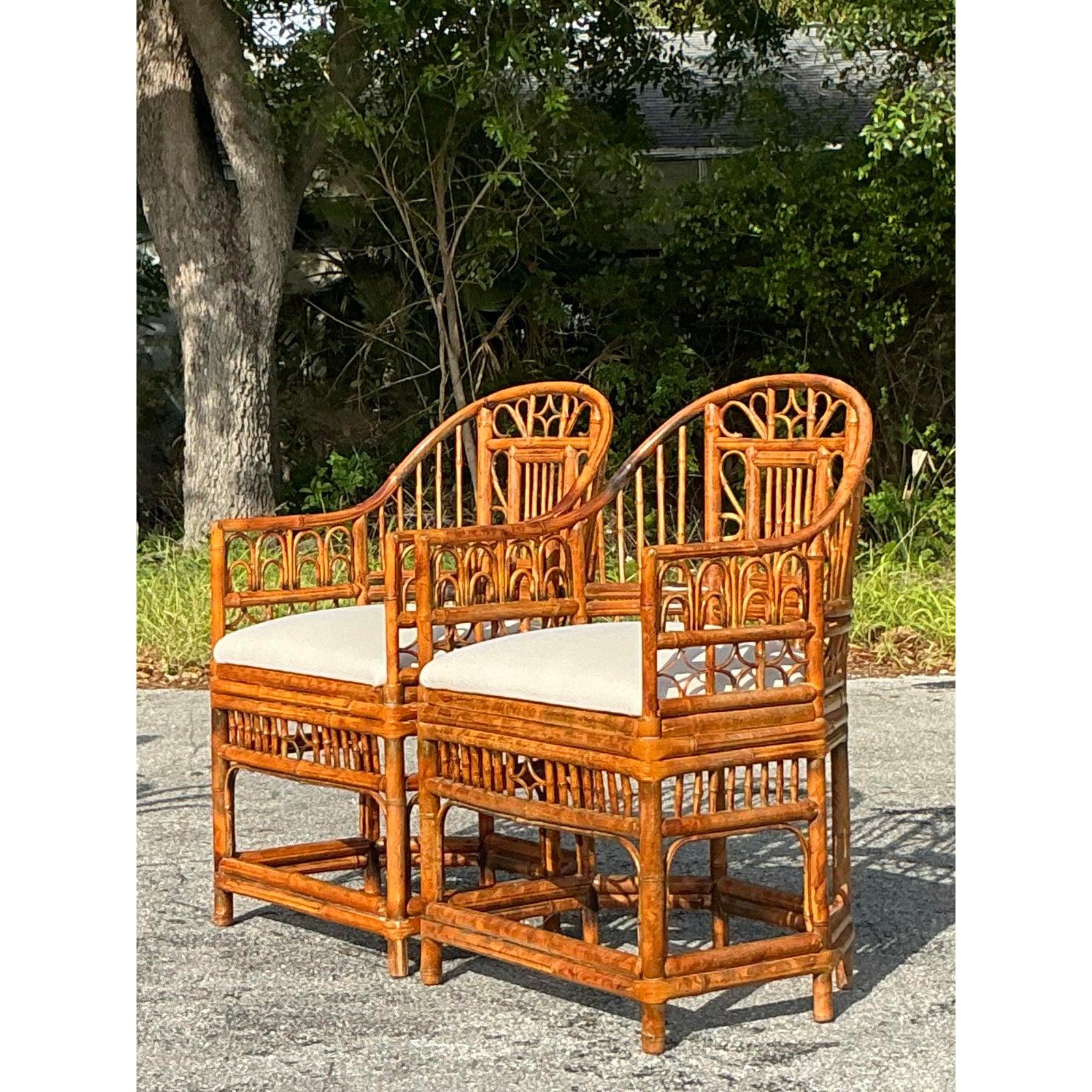 Add a touch of elegant coastal charm to your home with this stunning pair of vintage tortoise rattan Brighton Pavilion chairs. Designed with an intricate latticework back, gracefully curved arms, and a rich tortoise-hued rattan frame, these chairs