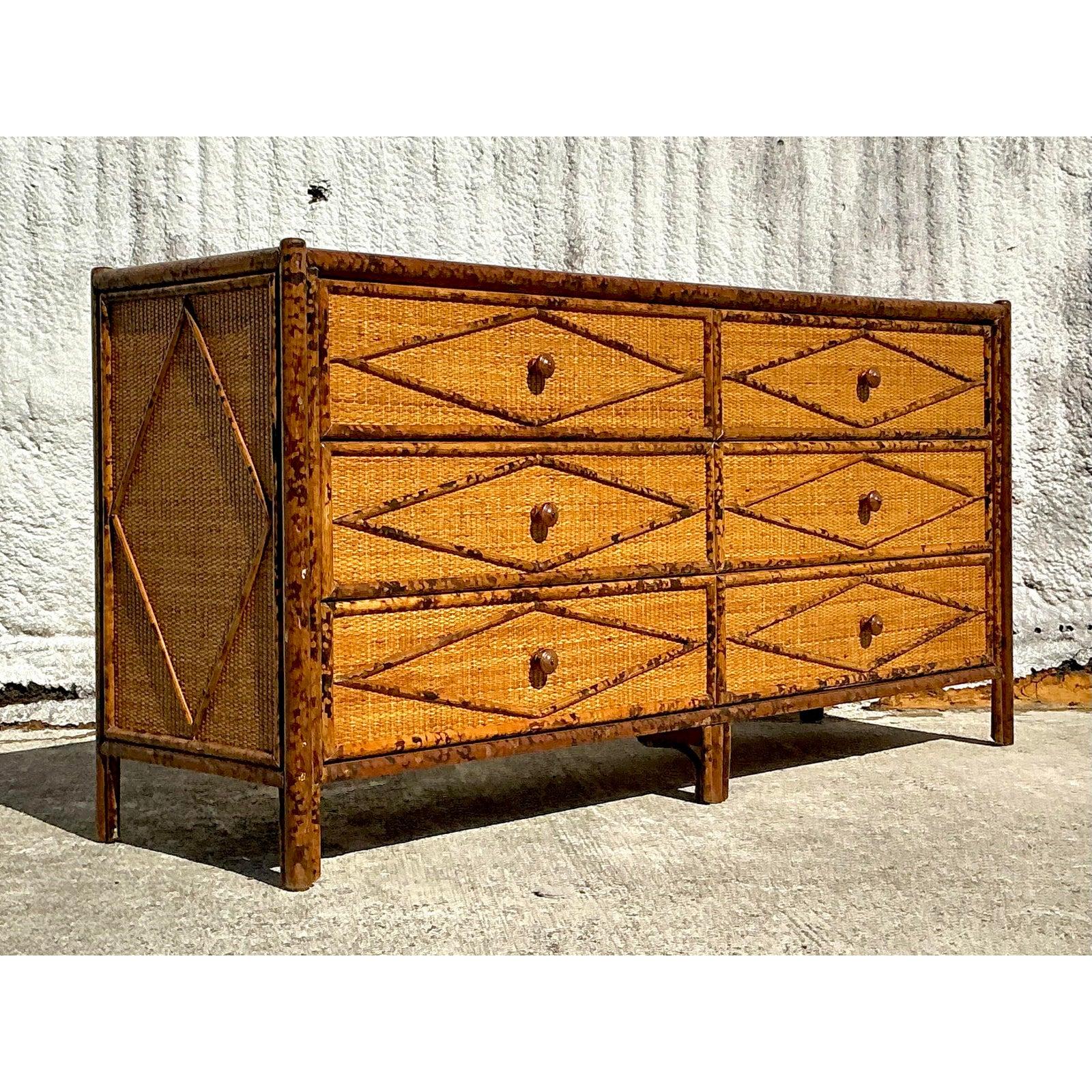 This vintage coastal tortoise rattan dresser is a statement of craftsmanship and natural elegance. Featuring a striking woven rattan facade with diamond-patterned detailing, this piece radiates warmth and organic charm. The tortoise shell-inspired
