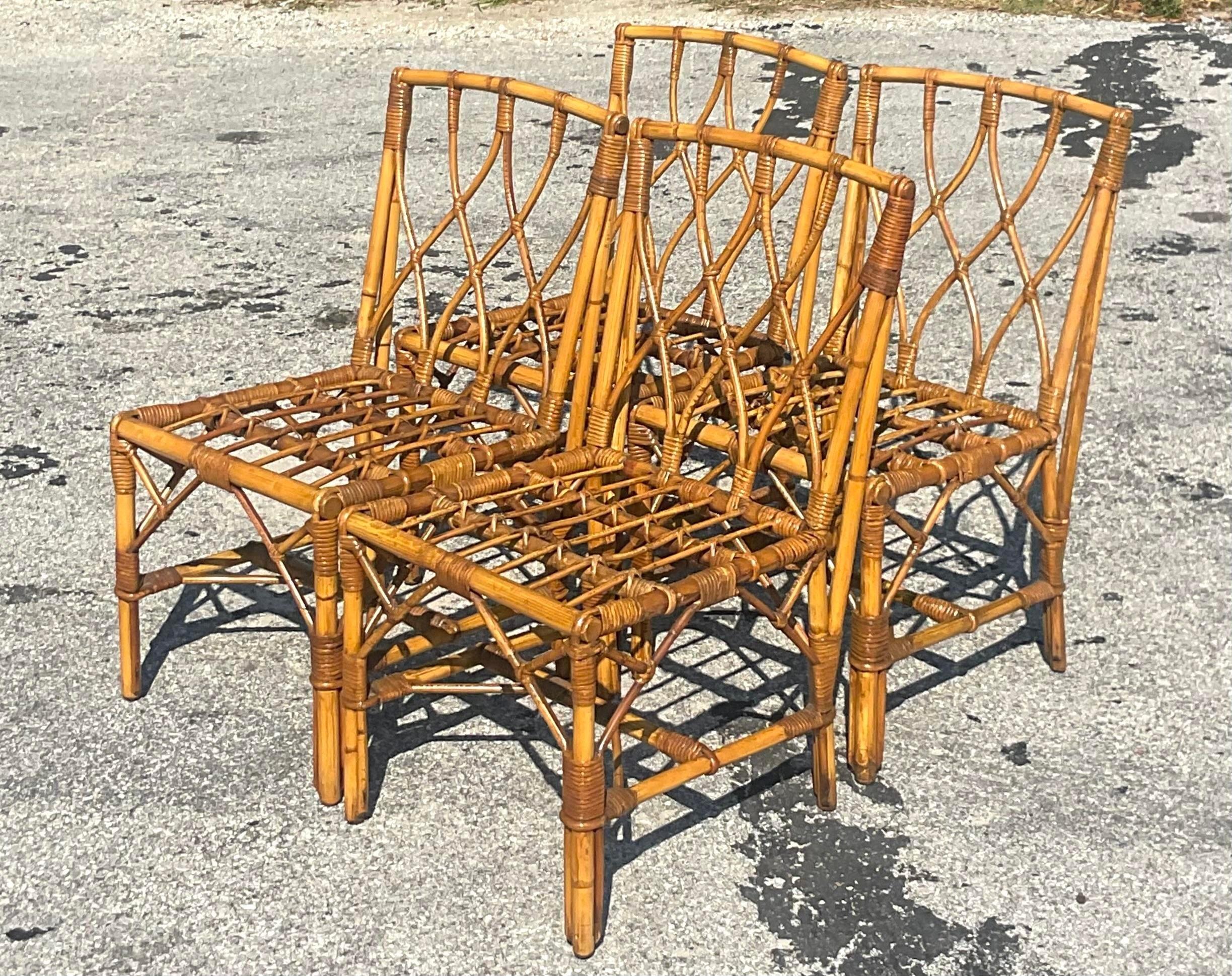 A fabulous set of four vintage Coastal dining chairs. A chic bent rattan in a trellis design. Acquired from a Palm Beach estate.