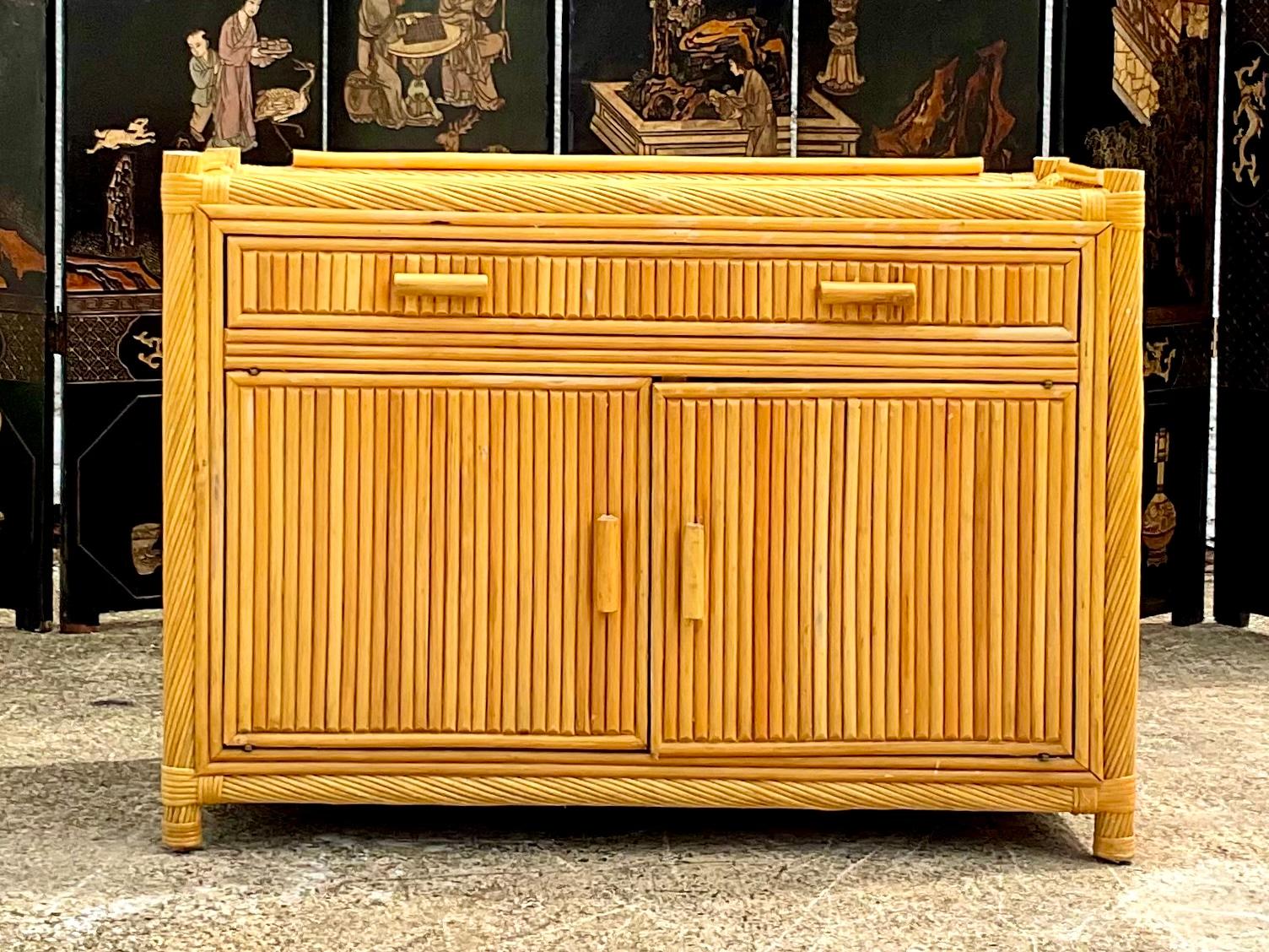 Fantastic vintage Coastal rattan credenza. A chic twisted rattan frame with inset rattan panel. Guard rails on top also make it great as a side board. Make it your own Island bar. Acquired from a Palm Beach estate.