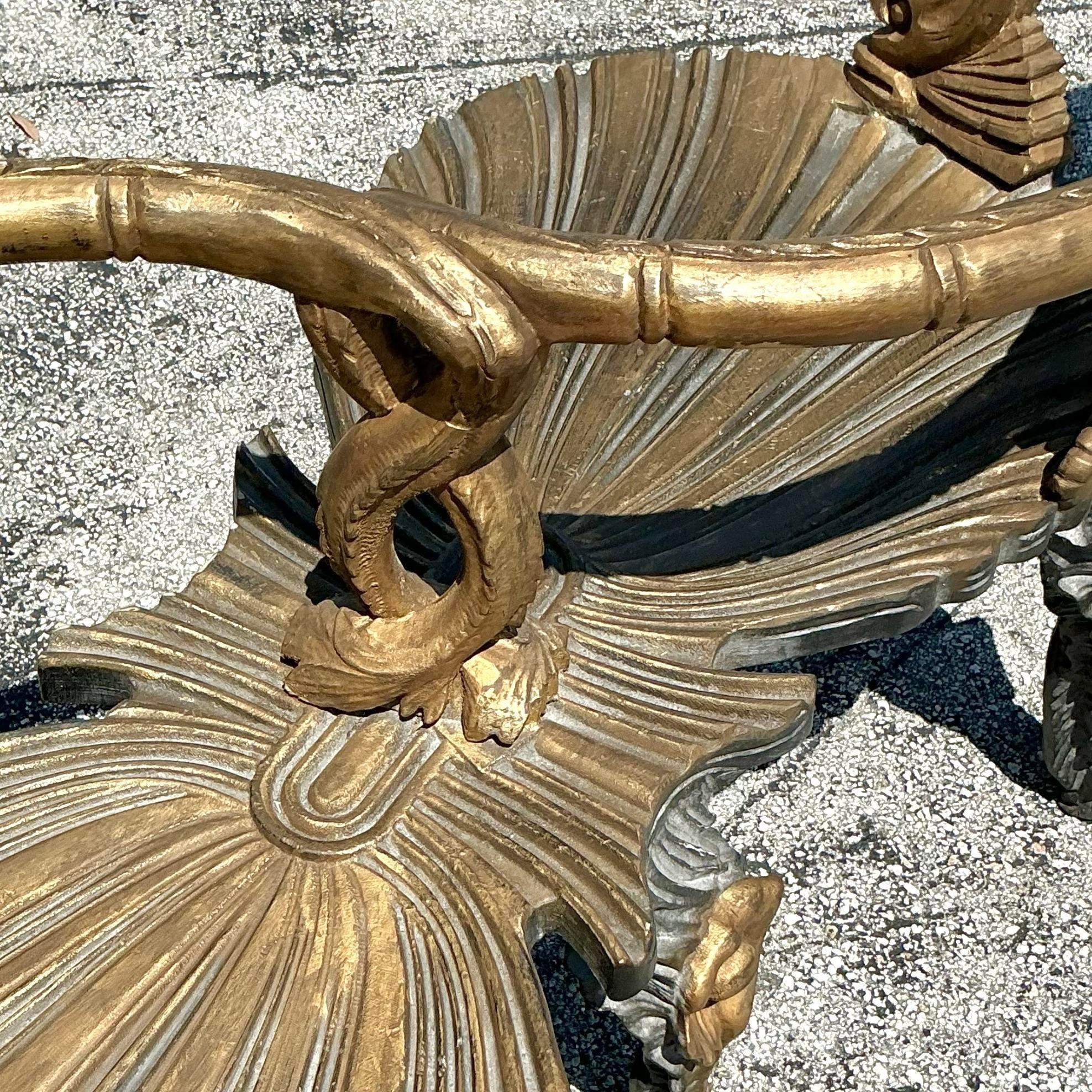 Rehaussez votre décor côtier avec cette exquise Tête-à-Tête de grotte vénitienne dorée vintage. Cette pièce rare et luxueuse présente un cadre sculpté de manière complexe, inspiré par la beauté organique de la mer, avec des motifs de coquillages et