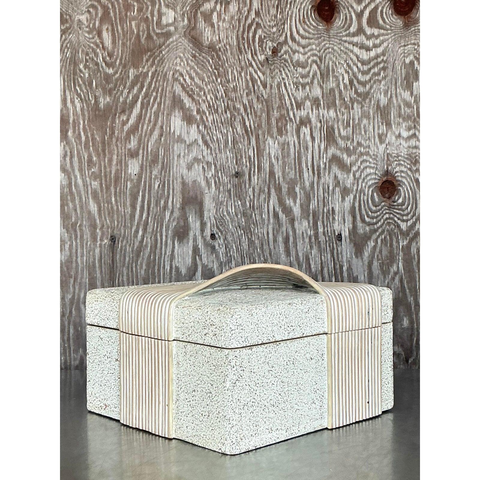 Diese Bleistiftschilfbox im Vintage-Stil, die mühelos Küstencharme mit organischem, modernem Stil verbindet, ist ein wahres Statement in Sachen skulpturaler Aufbewahrung. Mit seiner sandfarbenen, gesprenkelten Oberfläche und dem anmutig