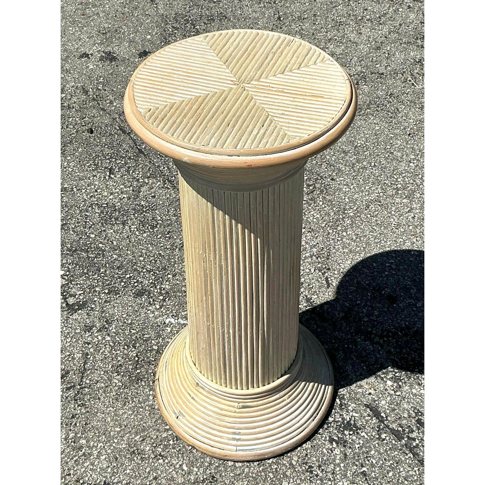 Bringen Sie einen Hauch von Küstencharme in Ihr Zuhause mit diesem wunderschön gefertigten Vintage-Säulenständer aus Schilfrohr. Mit seiner sanft gewaschenen Oberfläche und dem fein strukturierten, geriffelten Design ist dieser elegante Sockel die