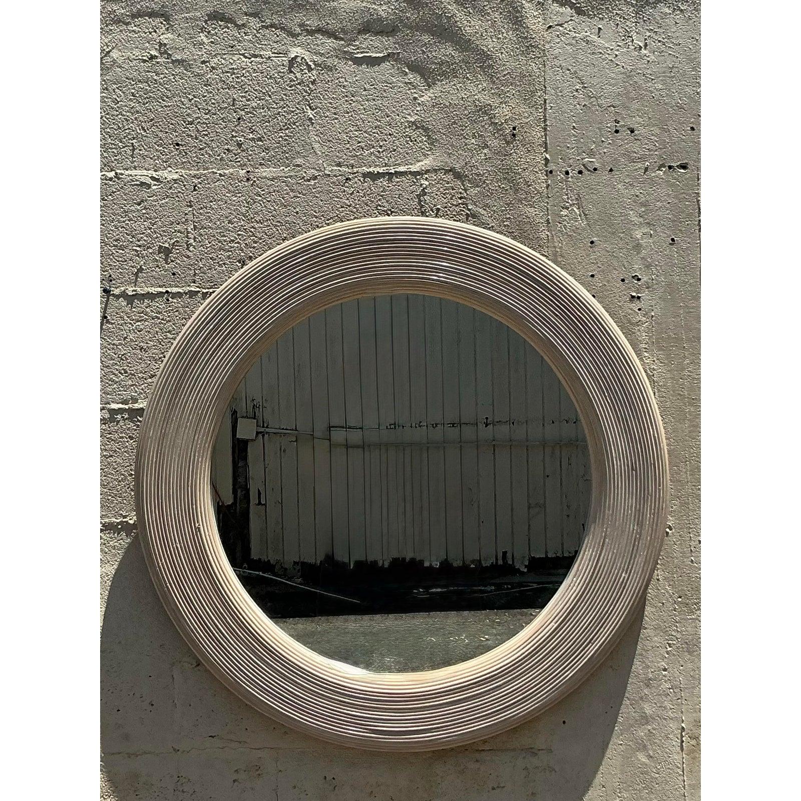 Introduci un tocco di texture naturale e di fascino costiero nel tuo spazio con questo sorprendente specchio rotondo vintage. La sostanziosa cornice è meticolosamente realizzata con canne di matita in fascio, disposte in cerchi concentrici per