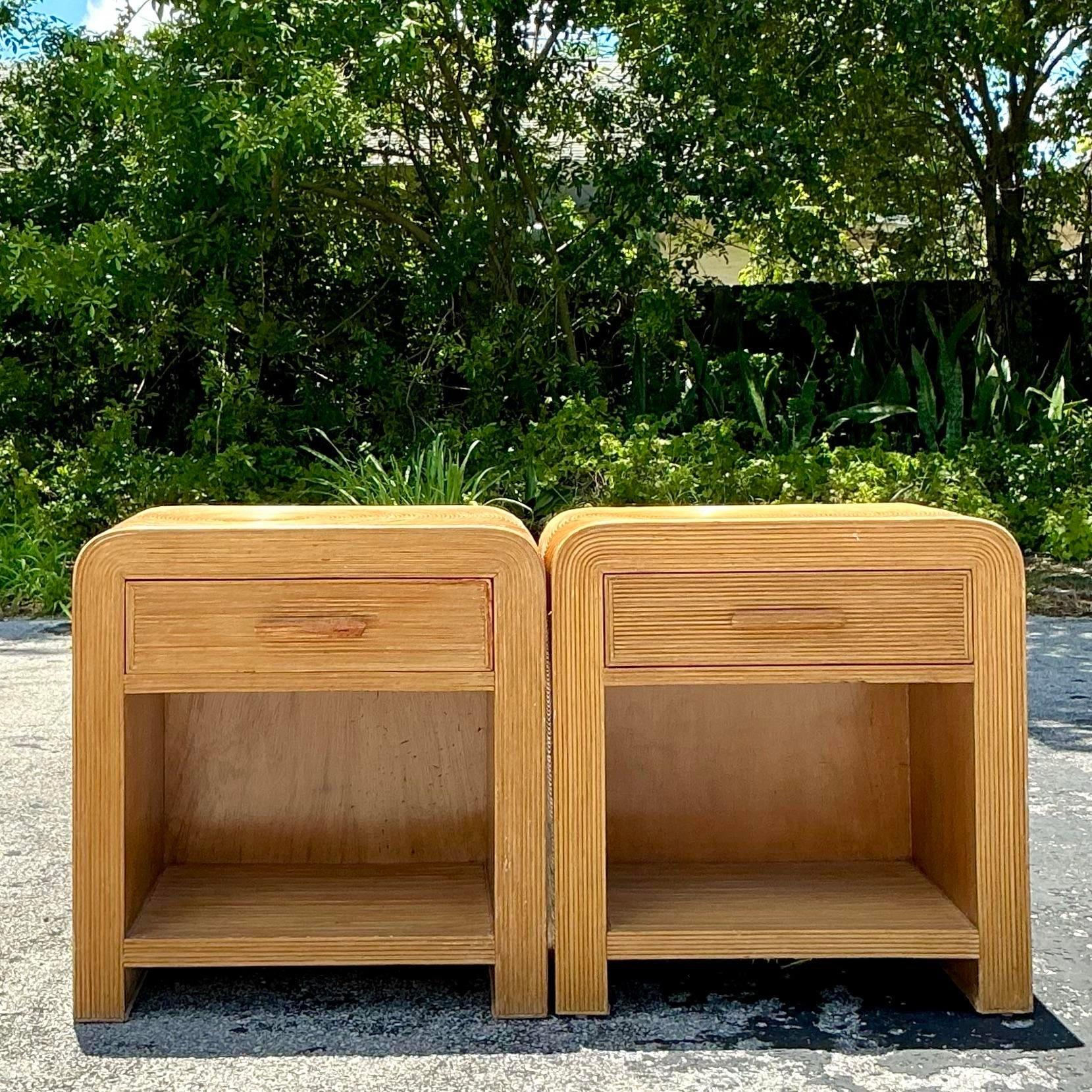 This pair of vintage coastal waterfall pencil reed nightstands exemplifies American coastal charm. Featuring gracefully curved waterfall edges and detailed pencil reed craftsmanship, these nightstands offer both style and practicality, perfect for