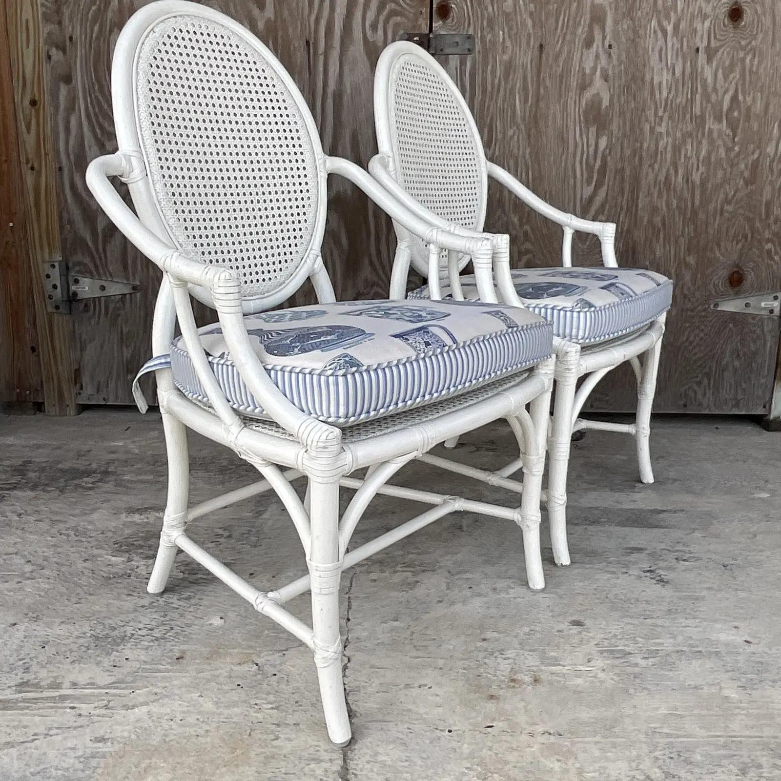 Fantastic pair of vintage McGuire Arm chairs. Beautiful rattan frame with inset cane panels. Lacquered in a semi gloss lacquered finish with a stunning blue and white ginger jar upholstery. Tagged on the bottom. Acquired from a Palm Beach estate.