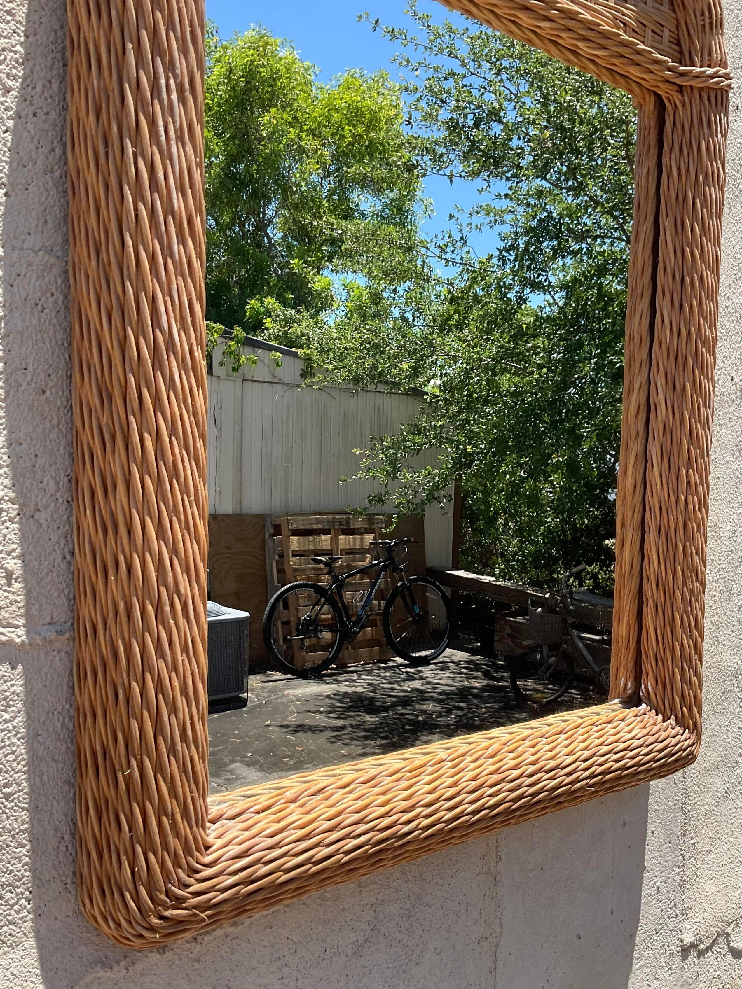 Holen Sie sich mit diesem gewölbten Spiegel aus geflochtenem Rattan im Vintage-Stil den entspannten Charme des Küstenlebens in Ihr Zuhause. Handgefertigt mit amerikanischem Flair, erinnern die natürliche Textur und das gewölbte Design an die Ruhe am