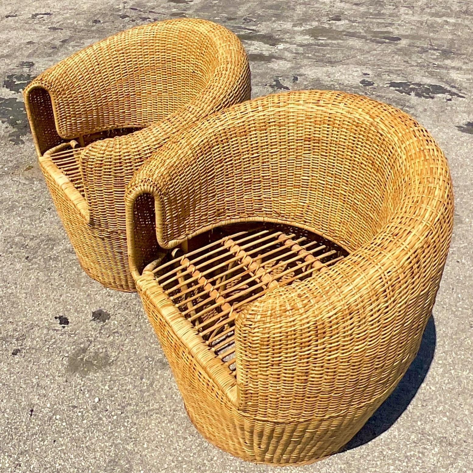 A fabulous pair of vintage Coastal Barrel chairs. Beautiful woven rattan in a chic modern shape. Acquired from a Palm Beach estate.