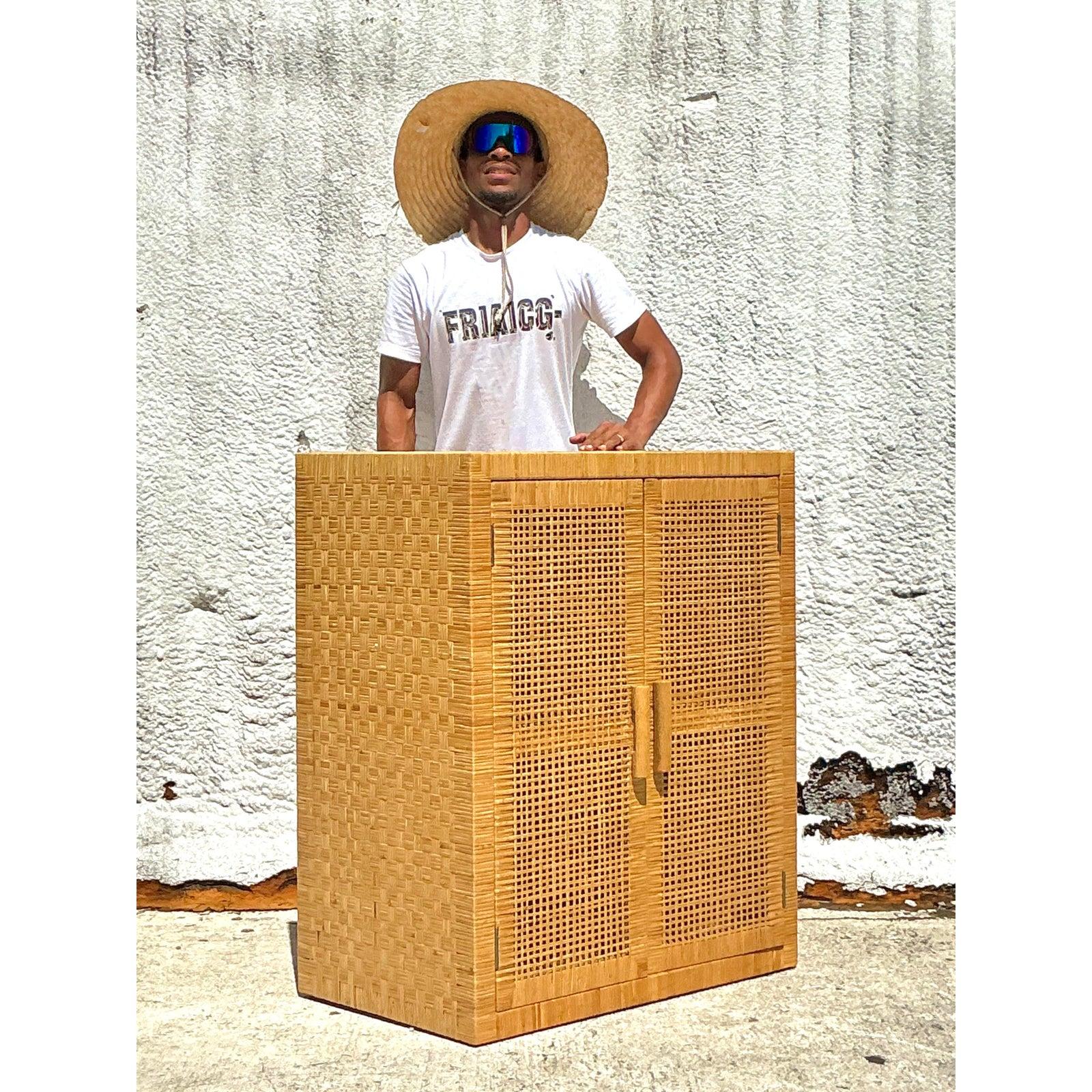 Bring relaxed coastal texture and versatile storage into your home with this charming vintage woven rattan cabinet. Wrapped entirely in natural rattan, featuring a distinct cane webbing pattern on the doors, this cabinet exudes a timeless, organic