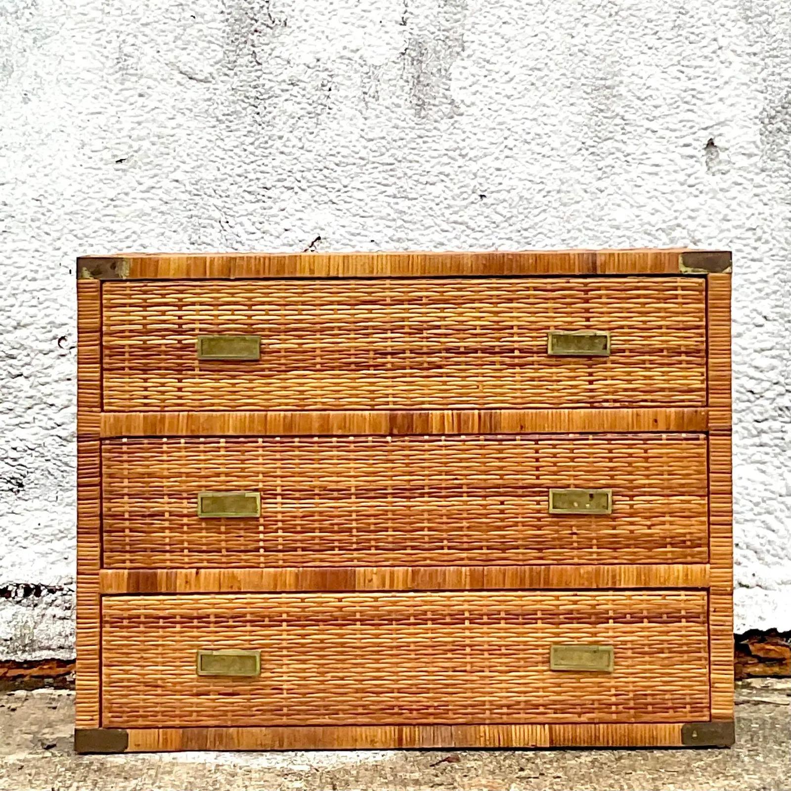 A fabulous vintage Coastal chest of drawers. Beautiful woven rattan with chic brass campaign details. Acquired from a Palm Beach estate.