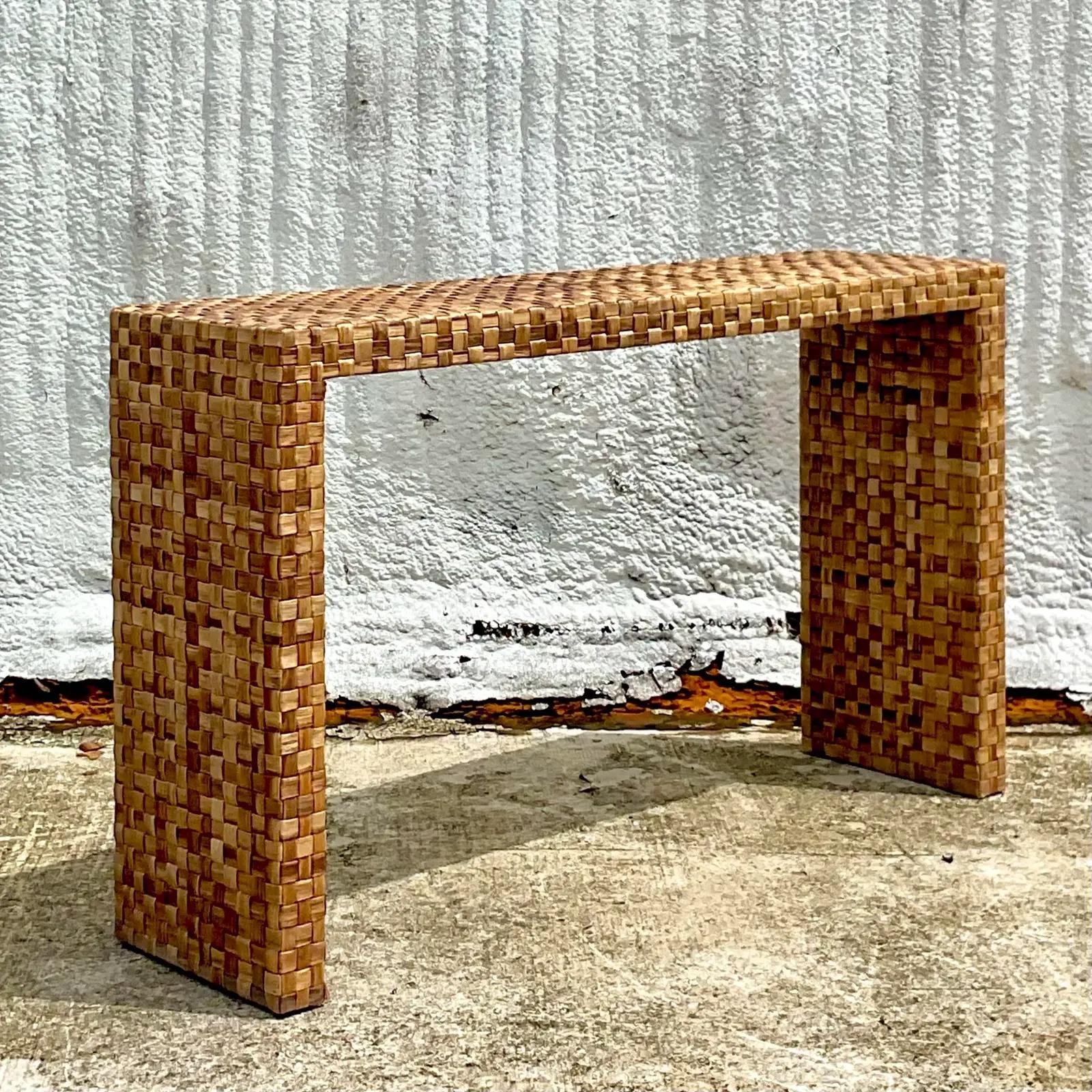 A fantastic vintage Coastal console table. A beautiful woven rattan construction on a chic and simple shape. Acquired from a Palm Beach estate.