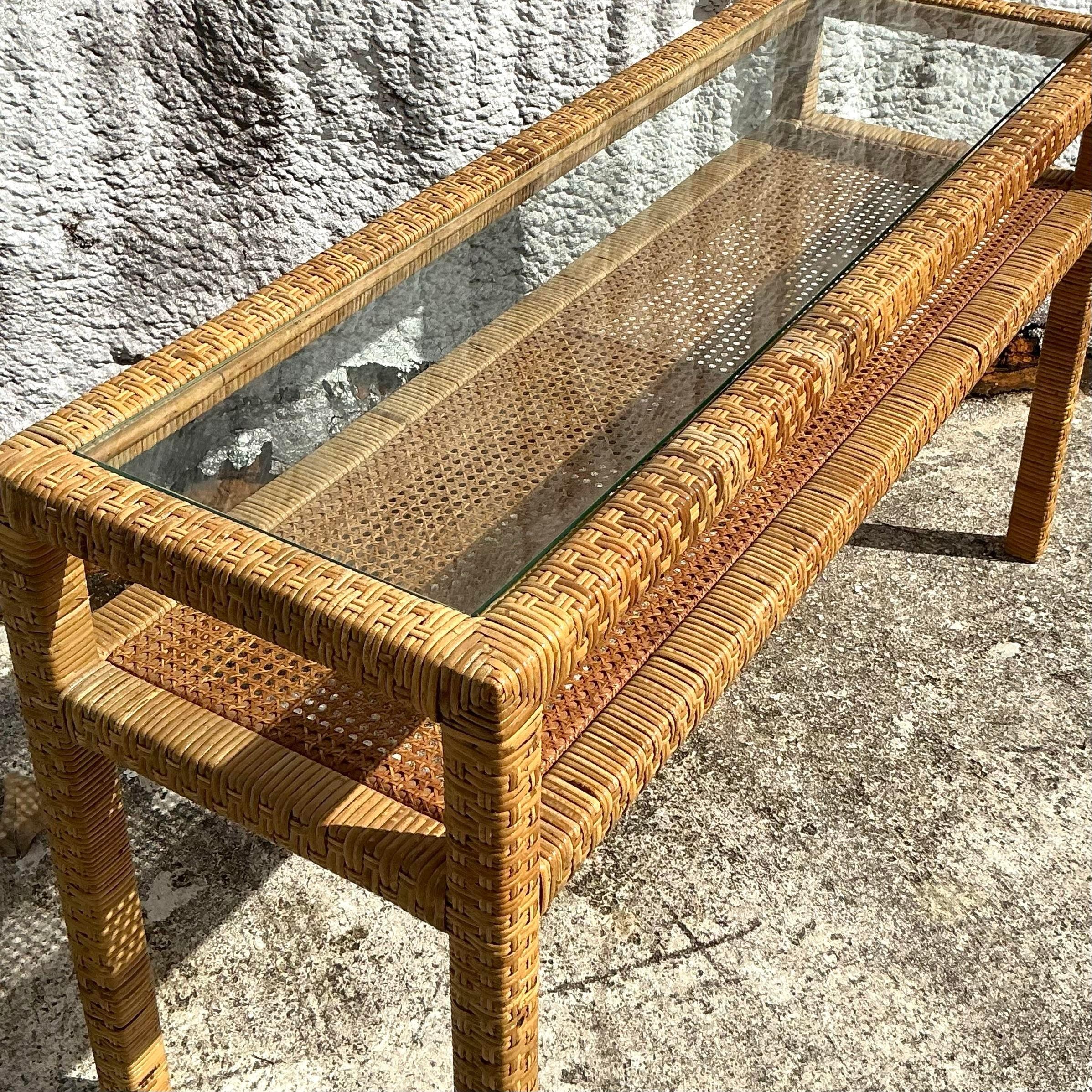 This vintage coastal console table, crafted from woven rattan, brings natural warmth and texture to any space. Its airy design and sturdy structure make it a versatile piece, perfect for an entryway, living room, or sunroom. With a relaxed,