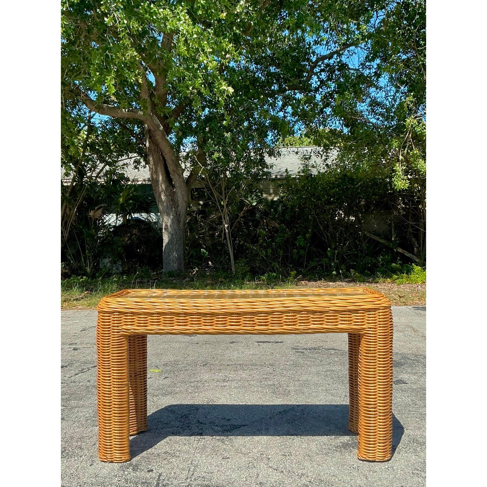 Dieser Konsolentisch aus geflochtenem Rattan im Vintage-Stil ist ein wunderschönes Stück, das organische Textur mit zeitlosem Küstencharme verbindet und Ihre küstennahe oder unkonventionelle Einrichtung aufwertet. Dieser vielseitige Tisch mit seinen