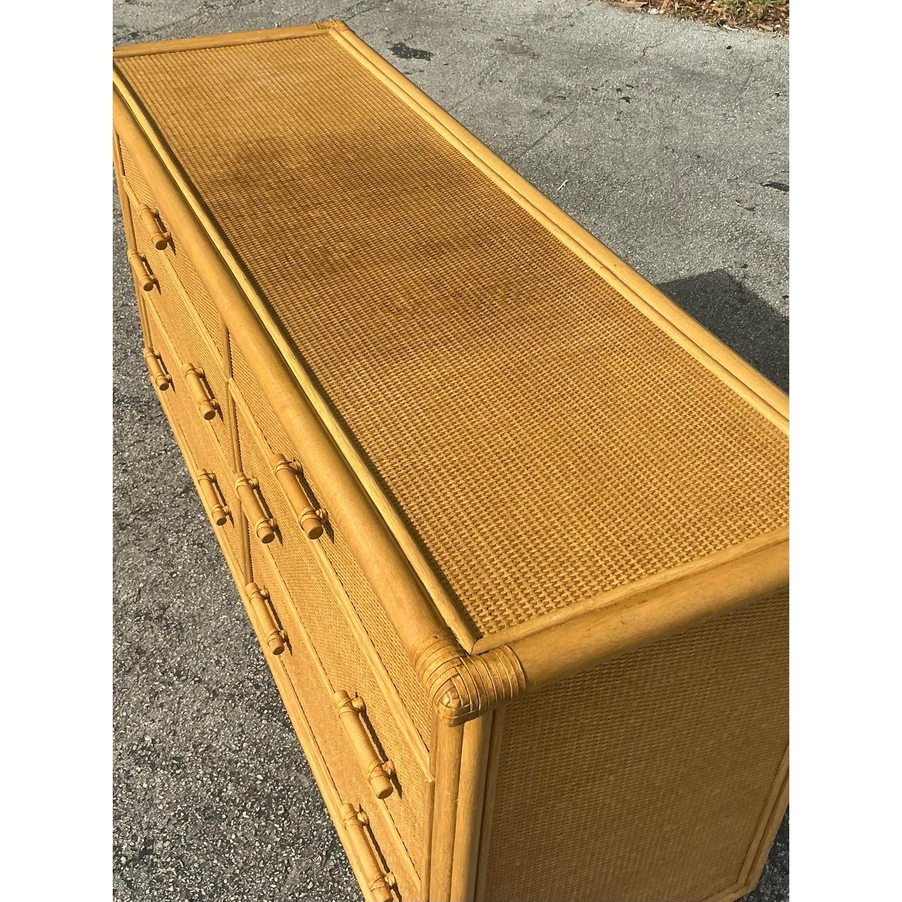 Valorizza il tuo spazio con il fascino caldo e organico di questa cassettiera vintage in rattan intrecciato. Dotato di sei spaziosi cassetti, questo pezzo di ottima fattura presenta intricati dettagli intrecciati e maniglie ispirate al bambù,