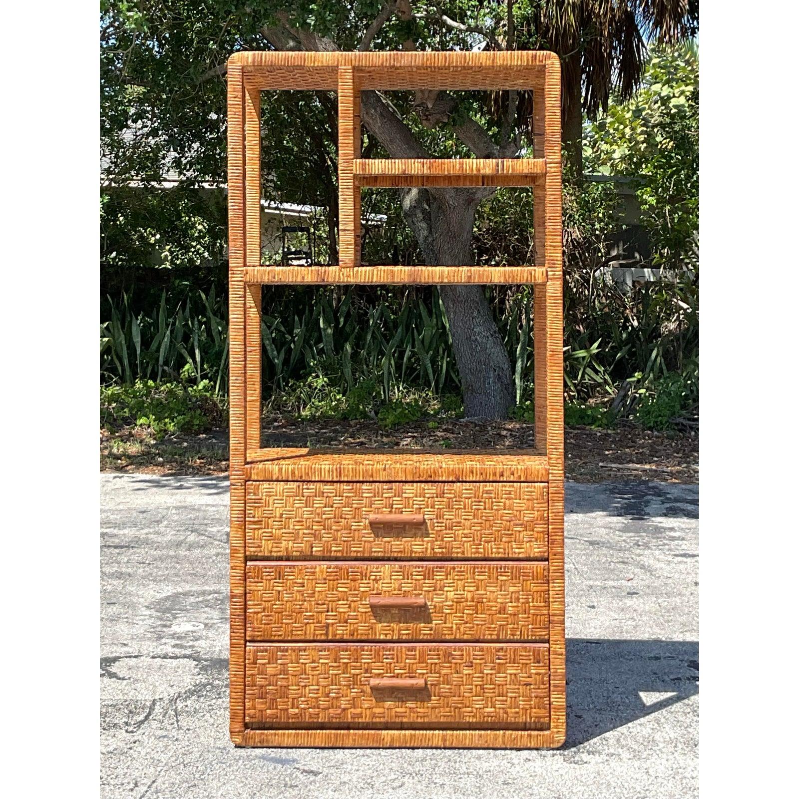 Bringen Sie natürliche Textur und küstennahen Charme in Ihr Interieur mit dieser wunderschönen handgeflochtenen Vintage-Rattan-Etagere. Mit seinen organischen Linien und dem asymmetrischen, offenen Regal ist dieses Möbelstück eine auffallende