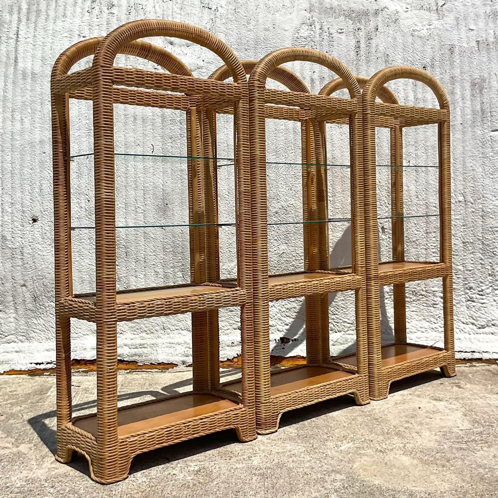 A fabulous set of three vintage Coastal etagere. Chic woven rattan in a clean arched design. Inset glass shelves. Acquired from a Palm Beach estate.

The etagere is in great vintage condition. Minor scuffs and blemishes appropriate to their age