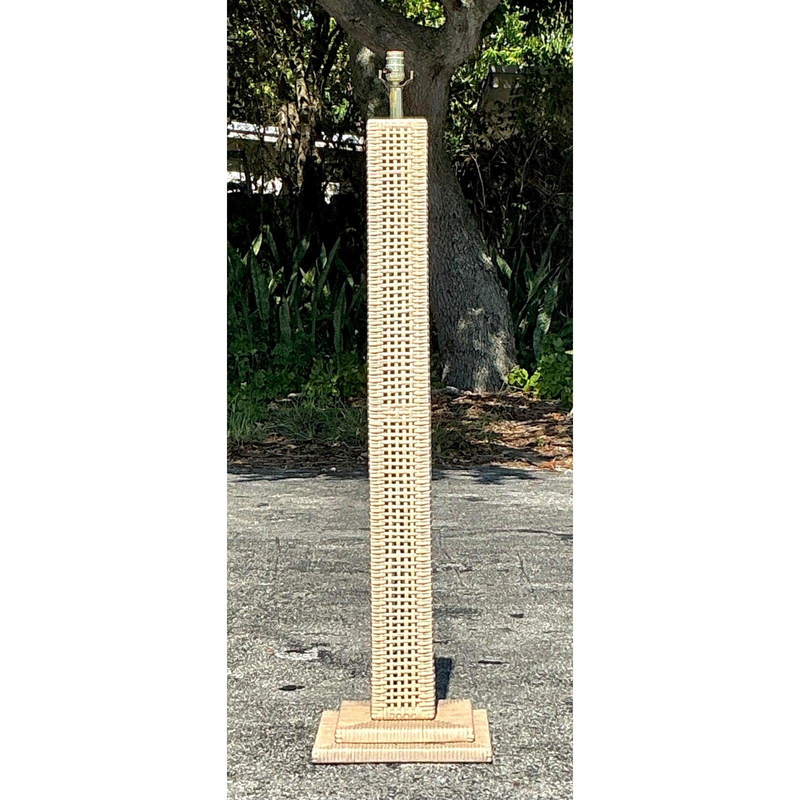 Ilumina tu espacio con el atractivo cálido y orgánico de esta lámpara de pie de ratán tejido vintage. Diseñada con una alta y esbelta silueta de columna cuadrada, esta pieza encarna una relajada estética costera y bohemia. El ratán natural está