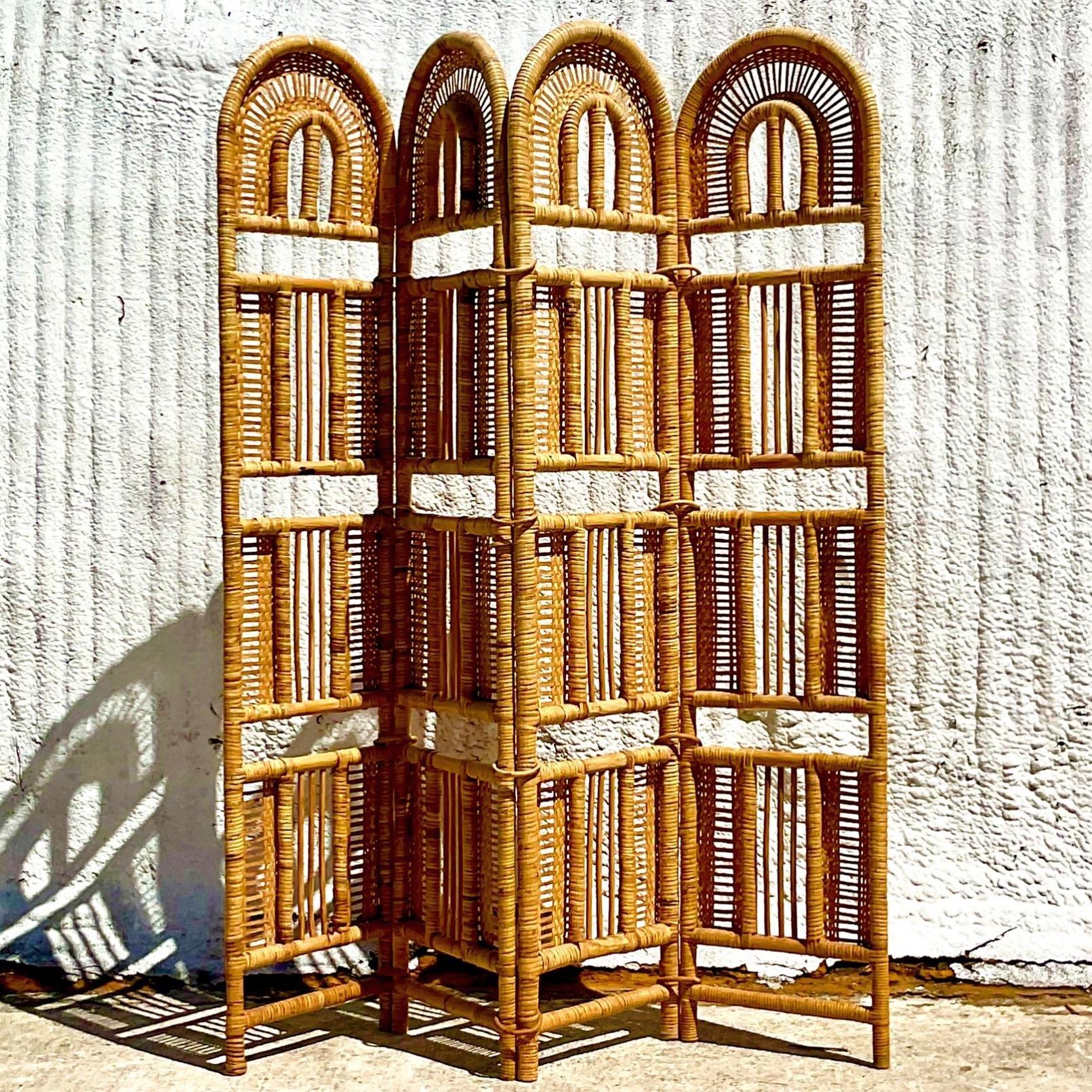 A fabulous vintage Coastal folding screen. Beautiful woven rattan in a chic contemporary design. Held together by large wrapped rattan rings. Acquired from a Palm Beach estate.