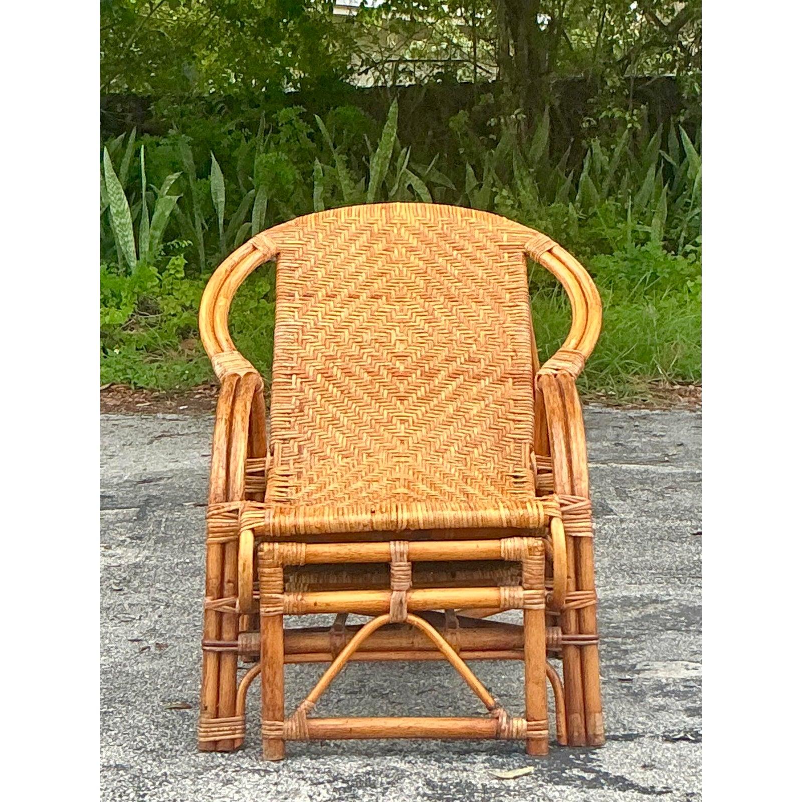 Embrace relaxed elegance with this exquisite vintage rattan lounge chair, a perfect fusion of coastal charm and bohemian artistry. Expertly handcrafted from natural woven rattan, this chair boasts an intricate, geometric pattern across its back and