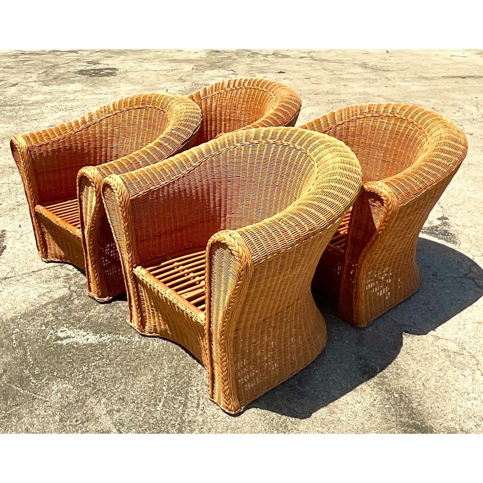 Gorgeous vintage woven rattan lounge chairs. A set of four roll back with deep relaxing seats. Acquired from a Palm Beach estate.