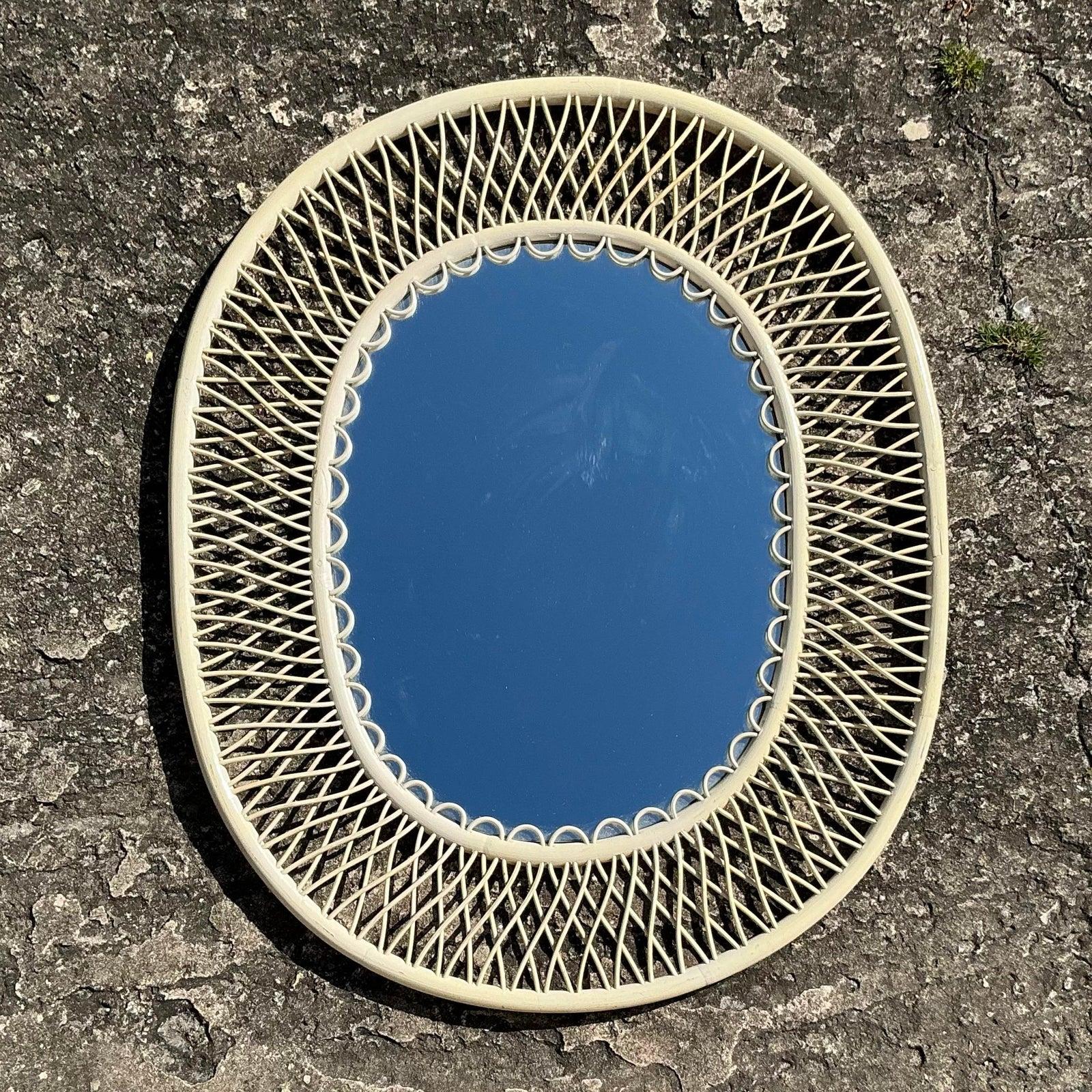 Ajoutez une touche de charme côtier à votre espace avec cet exquis miroir vintage en rotin tressé. Le design en treillis complexe entourant le cadre ovale renforce son attrait aérien et organique, ce qui en fait une pièce de déclaration parfaite