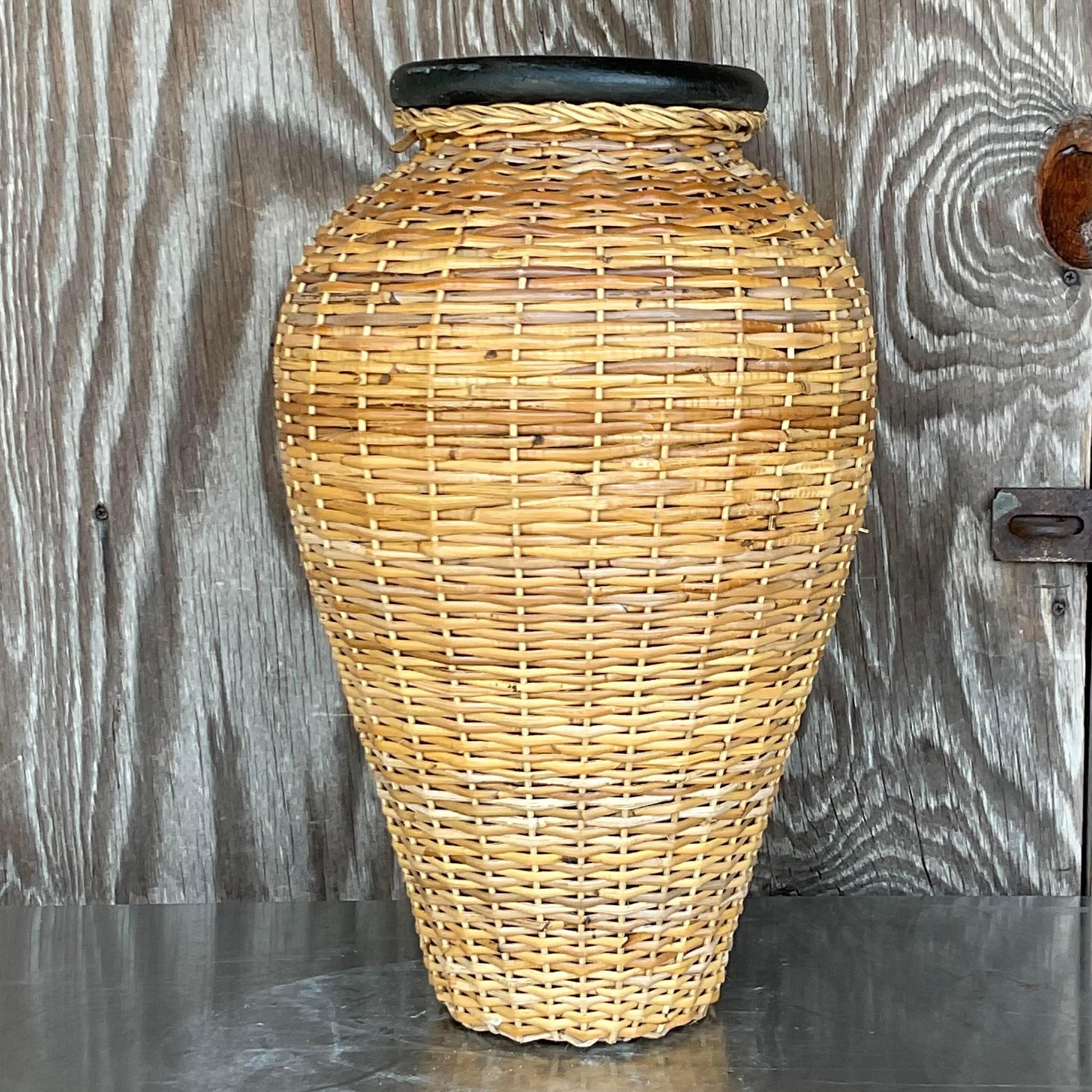 A fabulous vintage Coastal large vase. A beautiful woven rattan over a terracotta vase. Perfect indoors or outdoors in a covered space. Acquired from a Palm Beach estate. 