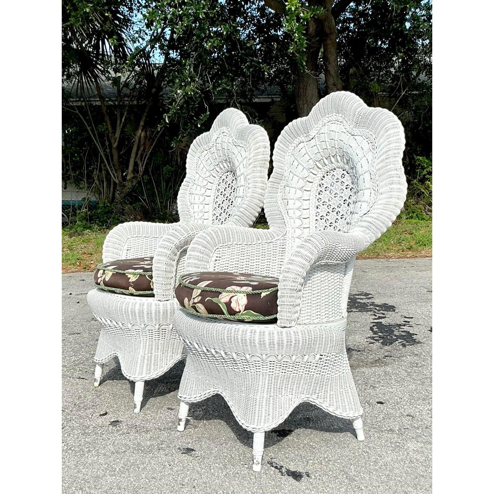 Bring home a touch of vintage coastal charm with this stunning pair of woven rattan peacock chairs. Featuring intricate open-weave fan backs and scalloped high arches, these chairs are a true testament to artisanal craftsmanship. The sculptural