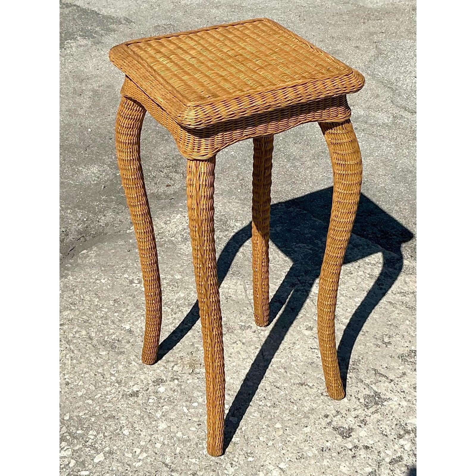 Infusez un charme côtier à votre espace en utilisant ce piédestal en rotin tressé vintage. Elegamment conçue avec des pieds cabriole légèrement incurvés et un plateau carré étroitement tressé, cette pièce est à la fois sculpturale et fonctionnelle -
