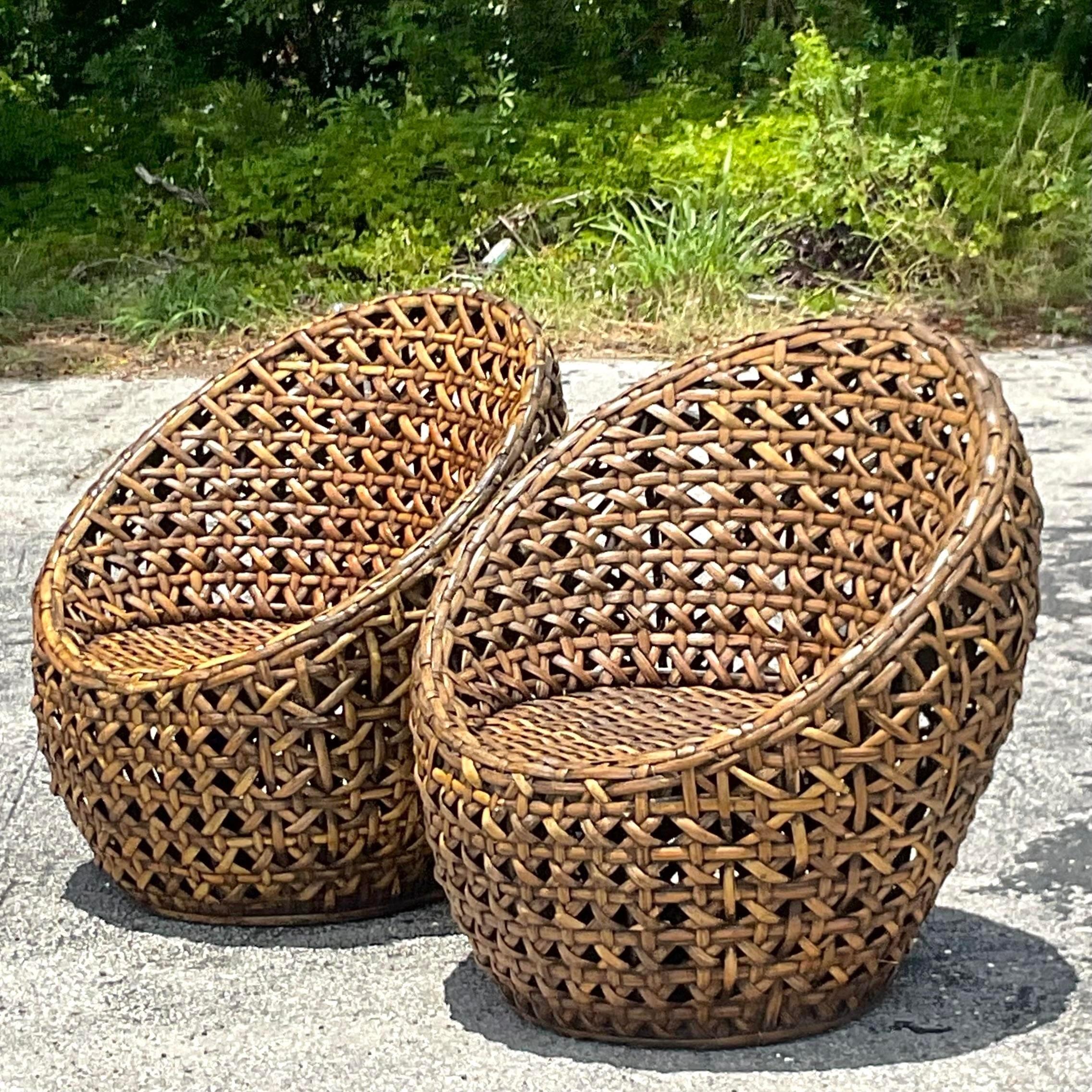 A fabulous pair of vintage Coastal pod chairs. Chic woven rattan in a rich coffee brown color. Acquired from a Palm Beach estate.
