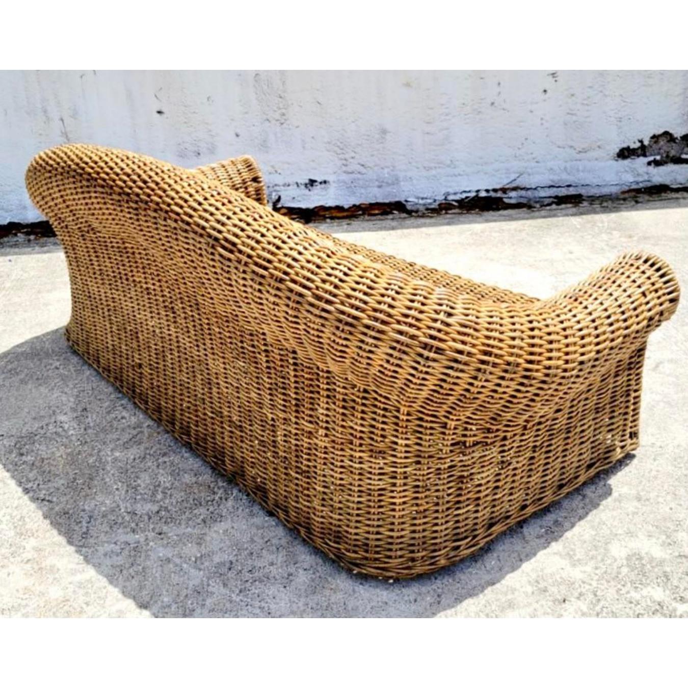 Fantastic vintage woven rattan sofa. An extra large frame with deep seats and an exaggerated roll back. Cushion included. Acquired from a Miami estate.