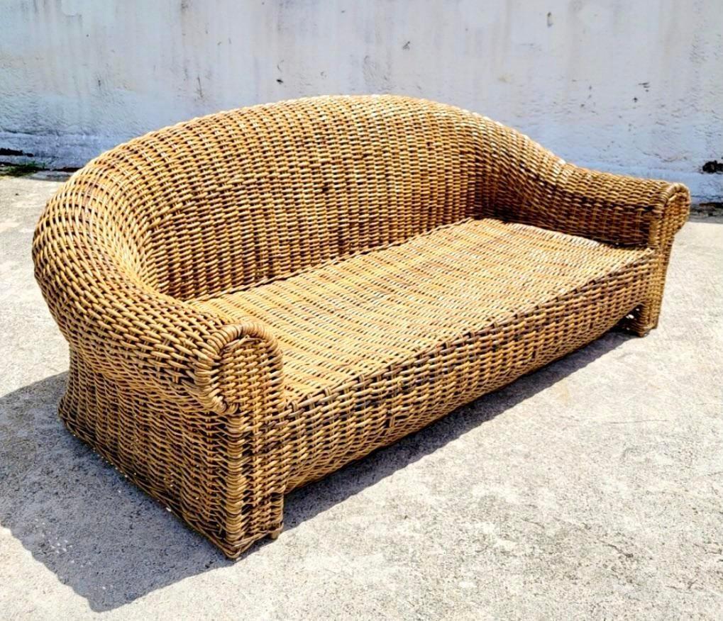 Fantastisches geflochtenes Vintage-Rattan-Sofa. Ein extragroßer Rahmen mit tiefen Sitzen und einem übertriebenen Rollback. Inklusive Kissen. Wurde aus einem Nachlass in Miami erworben.