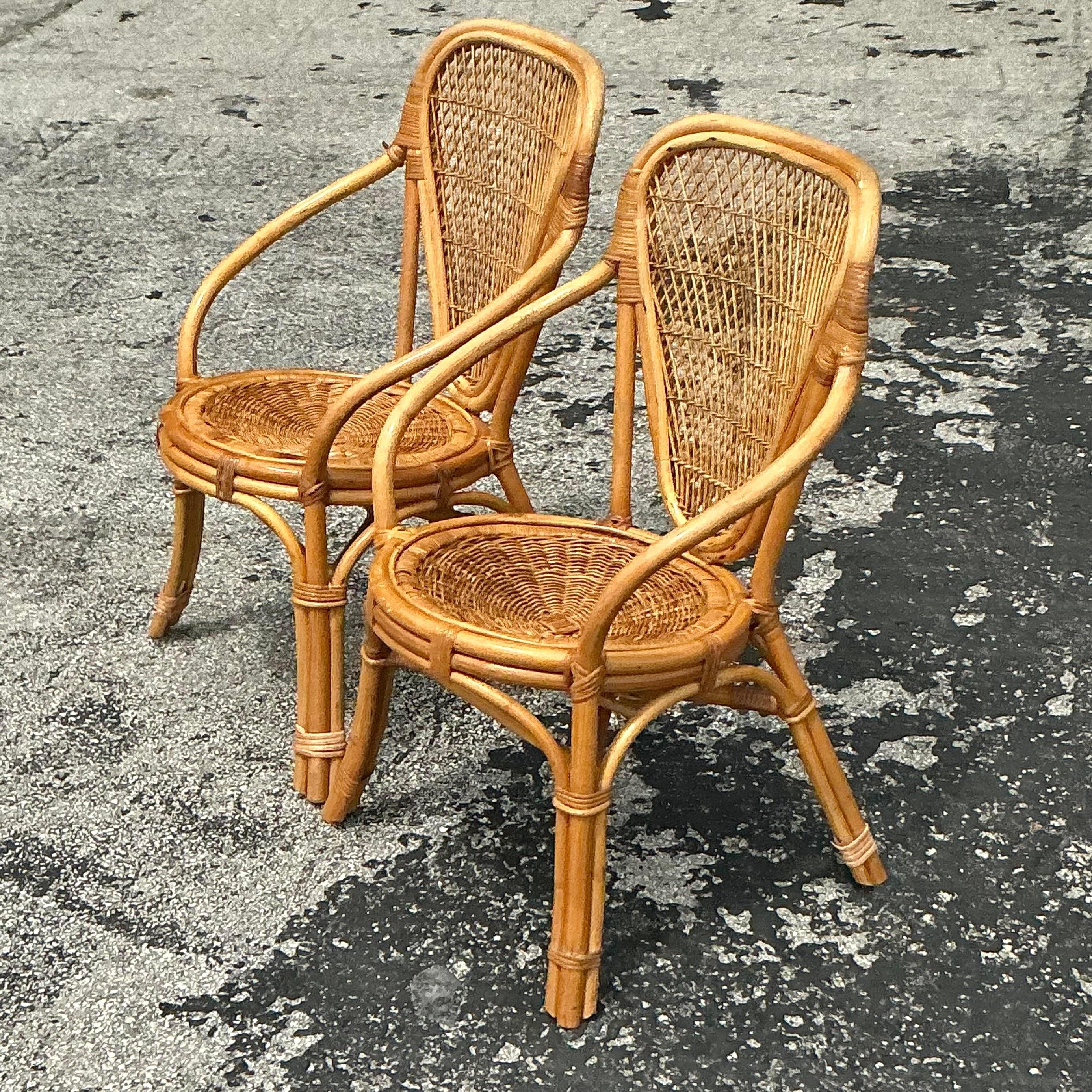 Arricchisci il tuo spazio con questa coppia di sedie vintage con schienale a scudo, realizzate in rattan. Il loro design distintivo e la loro texture naturale aggiungono un'eleganza rilassata e marina a qualsiasi ambiente.