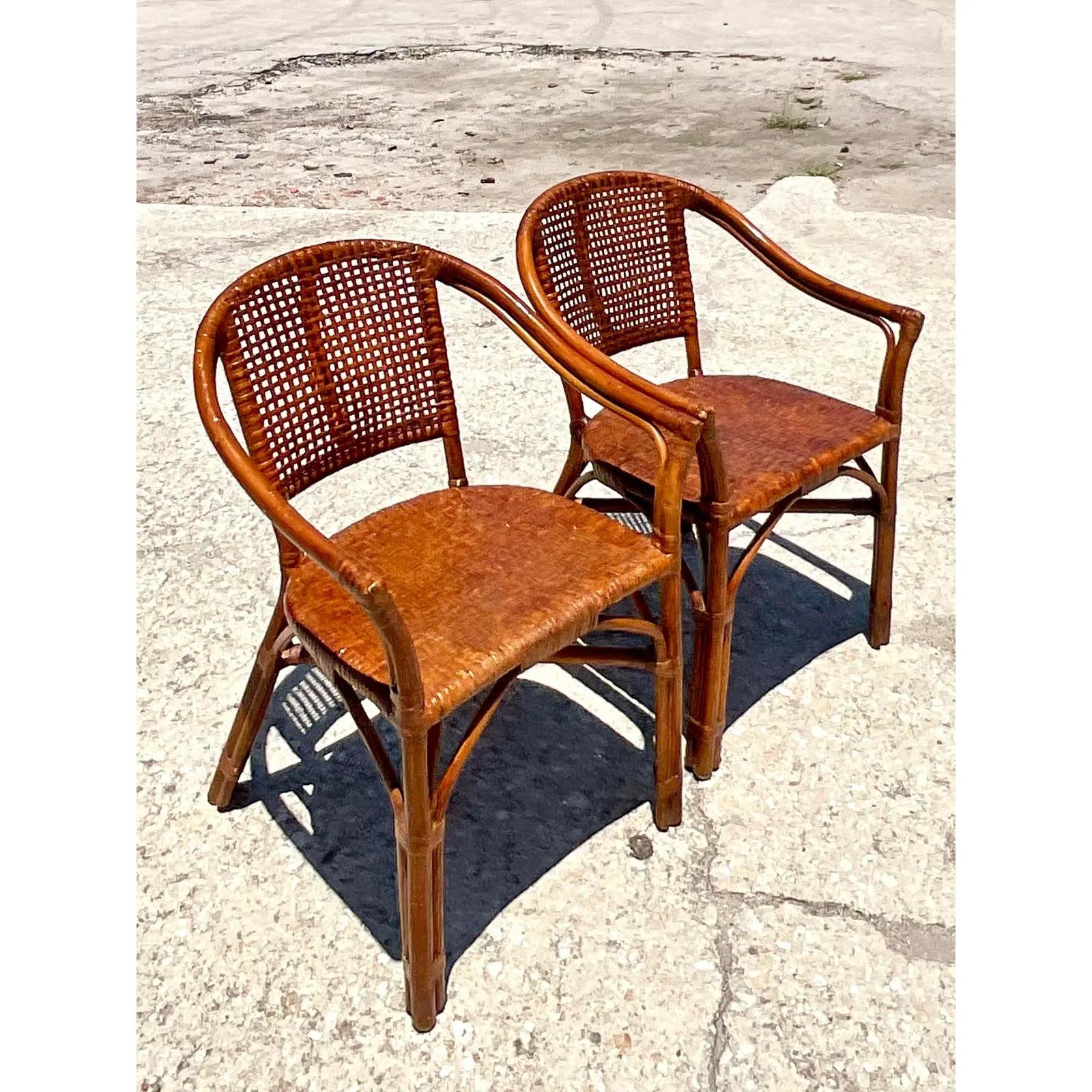 Fantastic pair of vintage Coastal side chairs. Beautiful woven rattan in a clean and open design. Perfect for addition seating or flanking your entry credenza. Super versatile. Acquired from a Palm Beach estate.