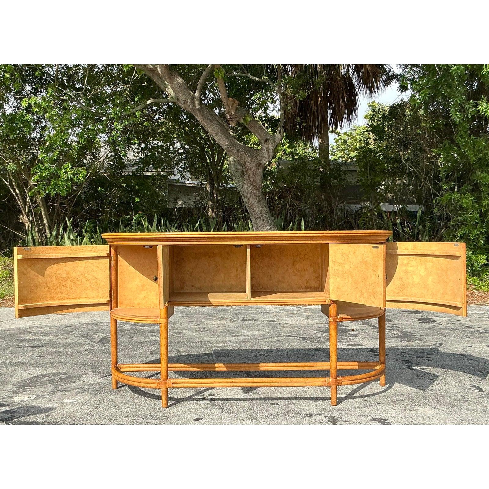 Bringen Sie einen Hauch von Küstencharme in Ihren Raum mit diesem atemberaubenden Sideboard aus geflochtenem Vintage-Rattan. Mit seiner anmutig geschwungenen Silhouette strahlt dieses Stück mühelose Eleganz und natürliche Schönheit aus. Die
