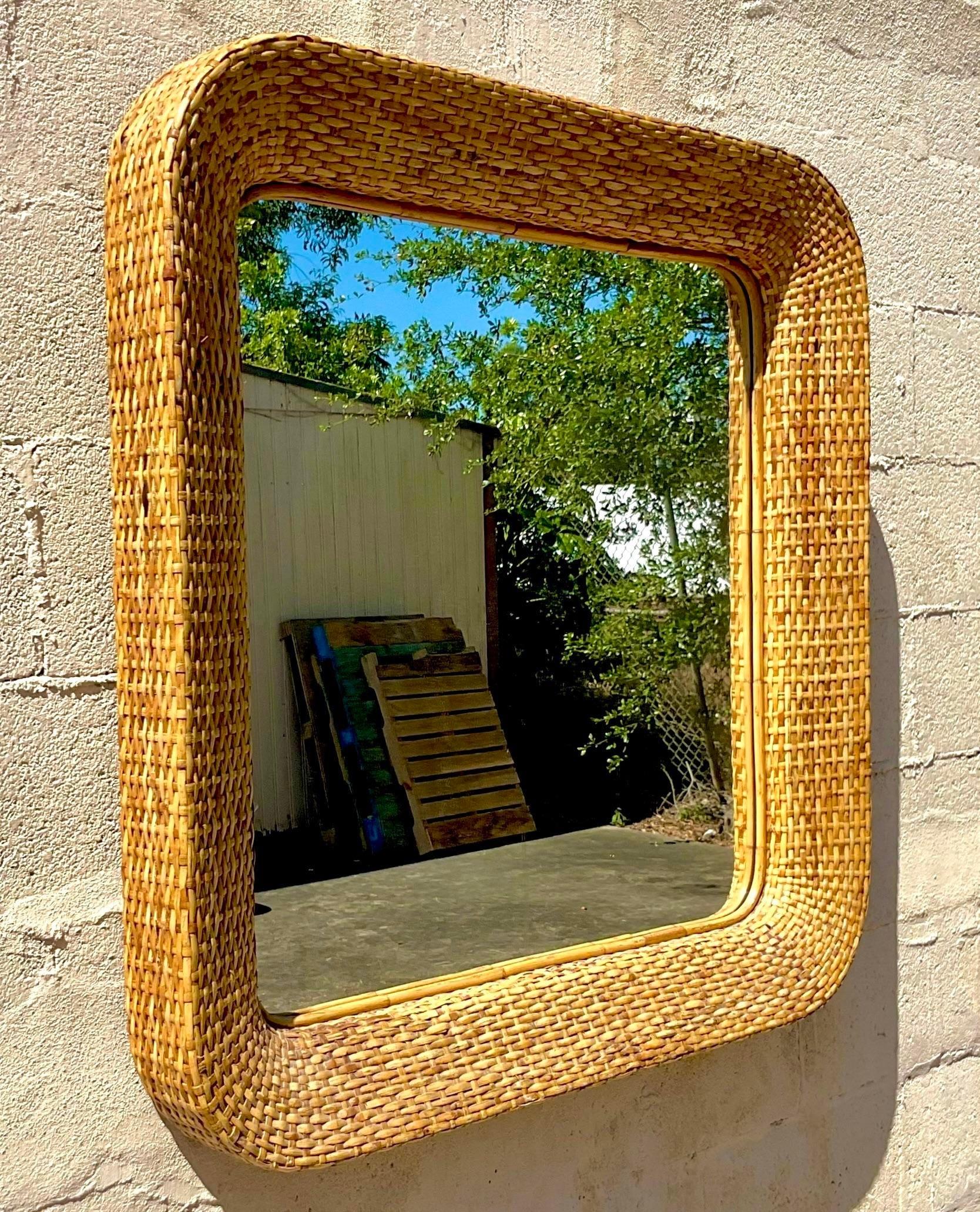 A fabulous vintage Coastal wall mirror. Chic woven rattan in a thick square frame. Acquired from a Palm Beach estate.