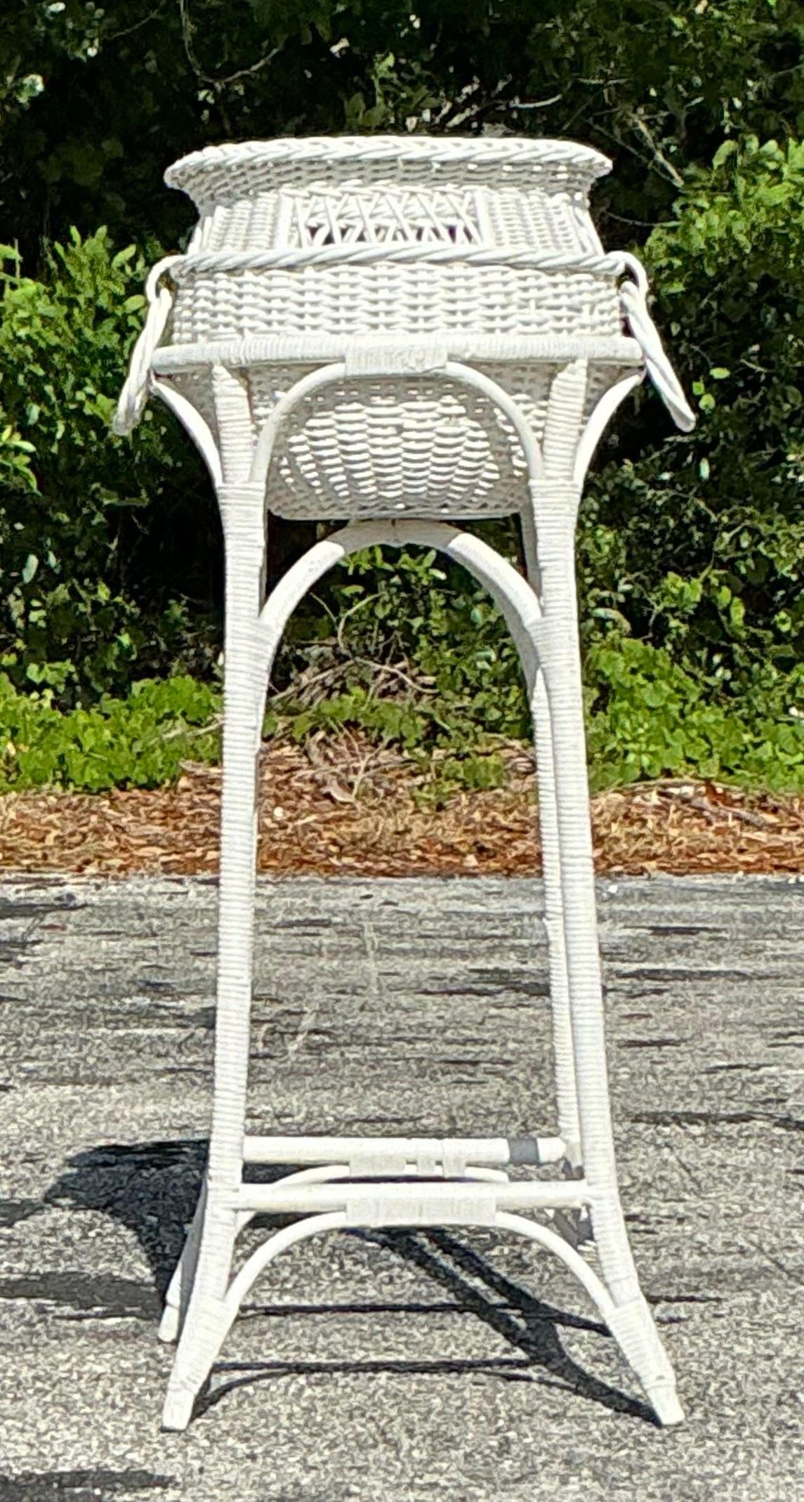 A fabulous vintage planter in a standing pedestal. Bright white woven rattan with a gorgeous large ring detail. Acquired from a Palm Beach estate.