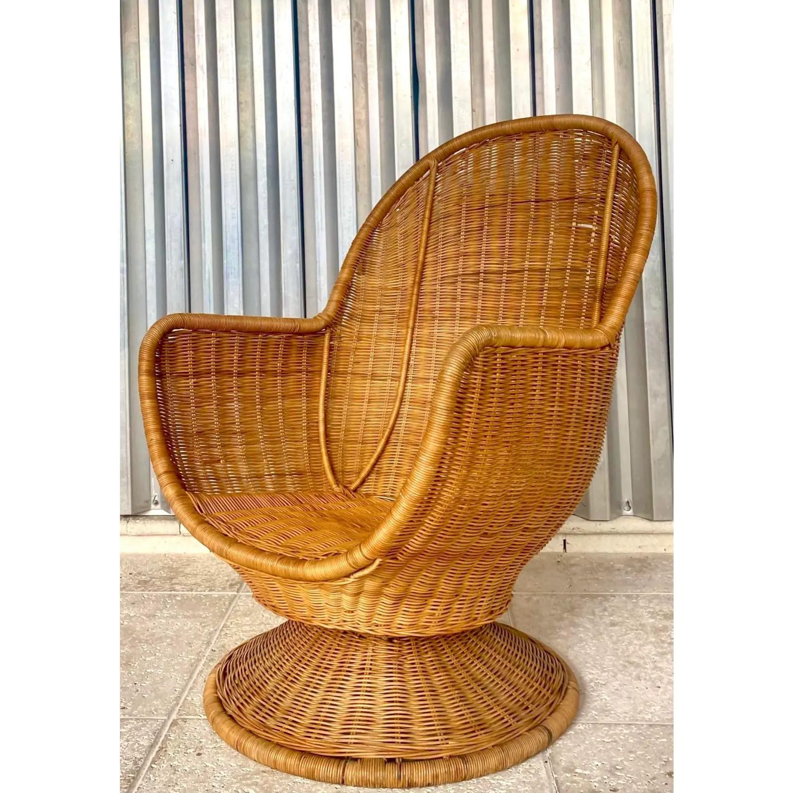 Fantastic vintage Coastal woven rattan swivel chair. A chic egg shape with high sides and back. Acquired from a Palm Beach estate.