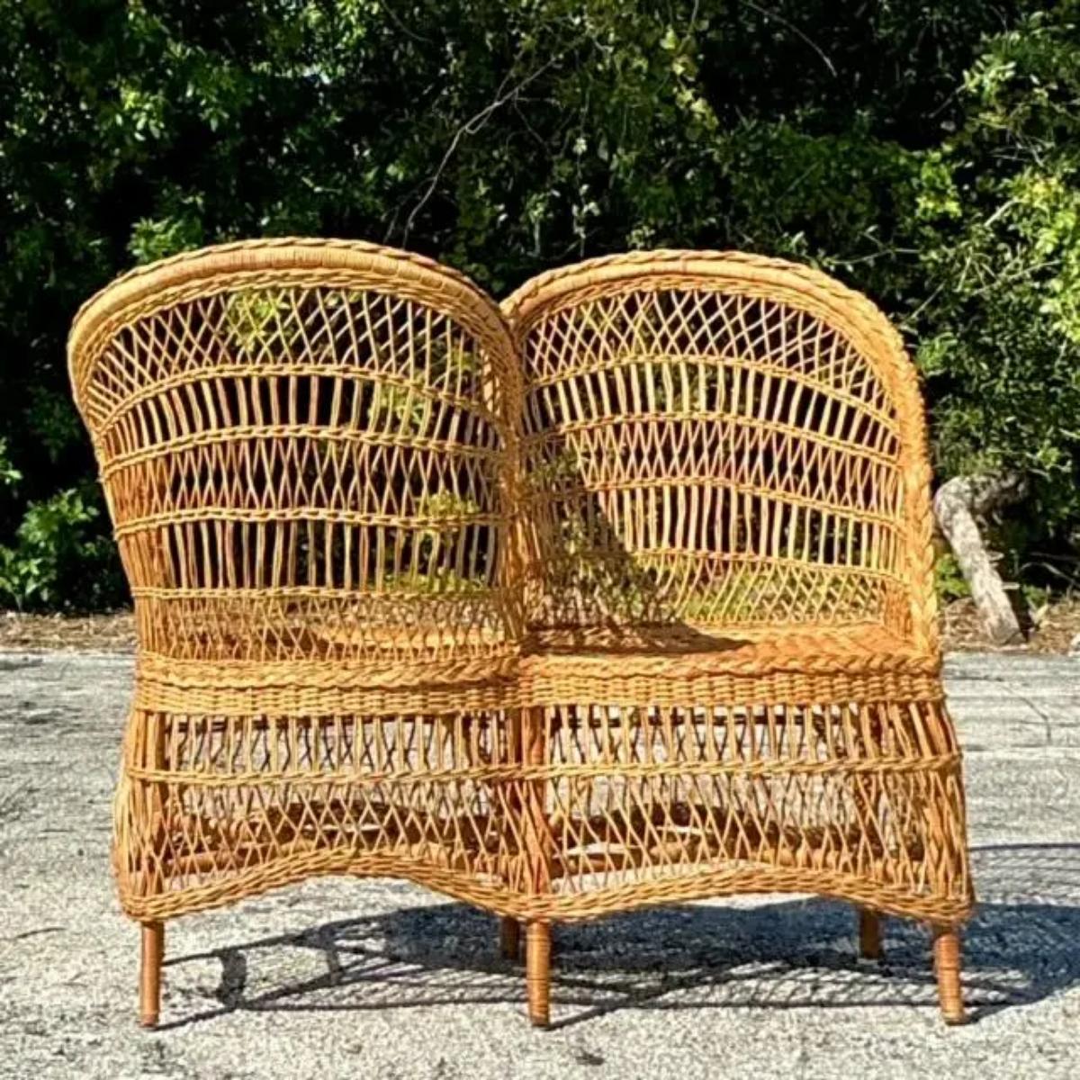 Élevez votre espace avec ce charmant canapé Tête-à-Tête Vintage Coastal en rotin tressé. Parfaite pour les conversations intimes ou pour se prélasser avec style, cette pièce unique présente un cadre en rotin magnifiquement tressé à la main qui