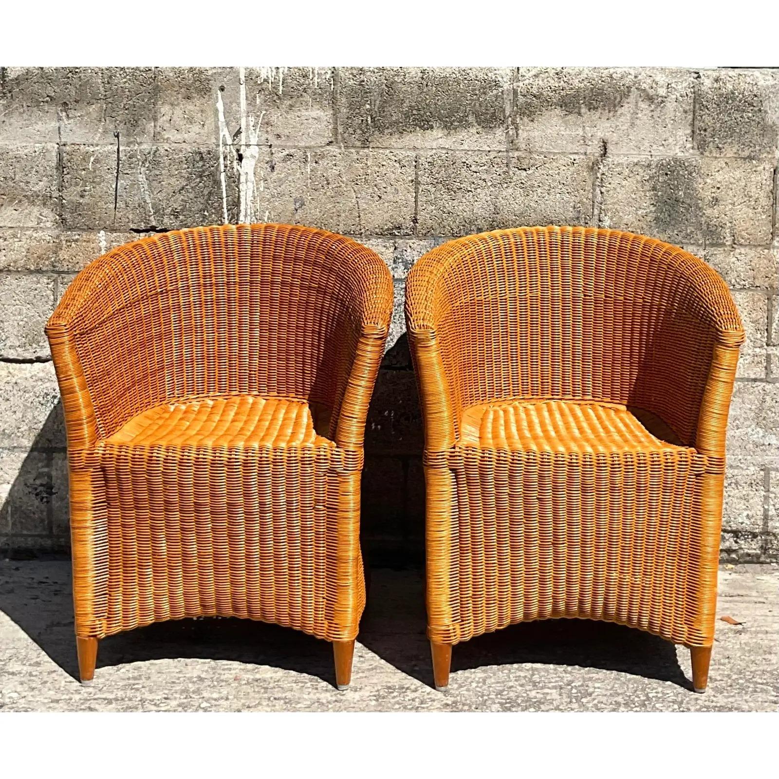 Fabulous pair of vintage Coastal tub chairs. Beautiful warm woven rattan in a contemporary design. Cushions included. Acquired from a Palm Beach estate.