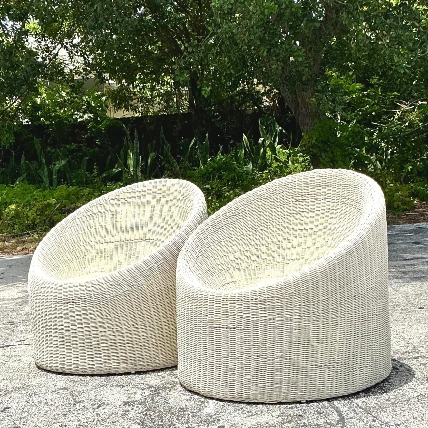 Ajoutez une touche de charme côtier à votre espace avec cette paire de chaises baignoires en rotin tissé vintage. Idéales pour les intérieurs de style américain, ces chaises présentent un élégant design en rotin tressé et une forme de baignoire