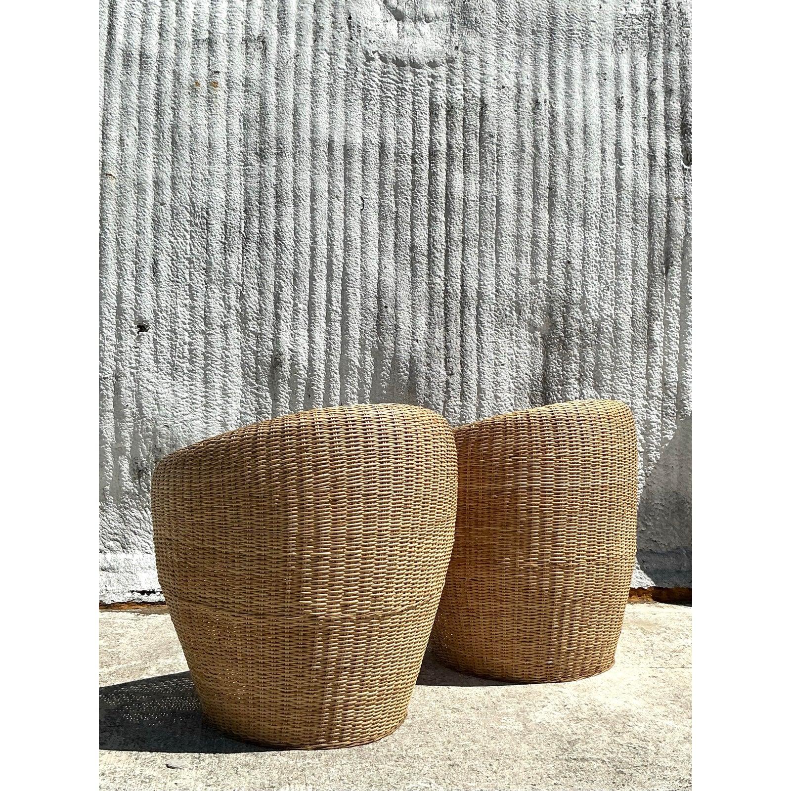 Embrace timeless coastal elegance with this stunning pair of vintage woven rattan tub chairs. Featuring a beautifully curved silhouette and intricate handwoven craftsmanship, these chairs exude natural warmth and organic charm. The open-arm design