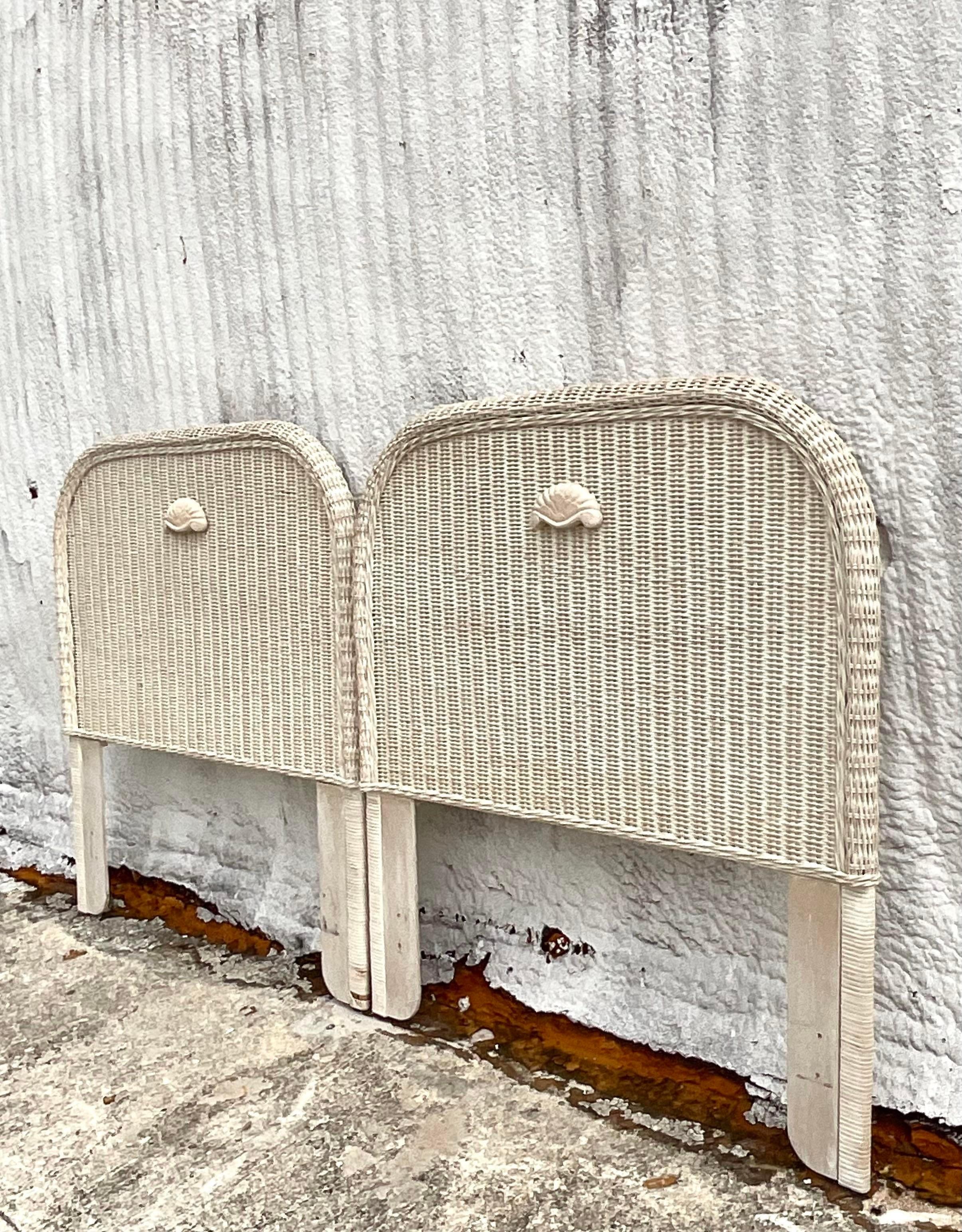 Fabulous vintage Coastal twin headboards. Beautiful woven rattan in a pale finish with carved wood shell detail. Acquired from a Palm Beach estate