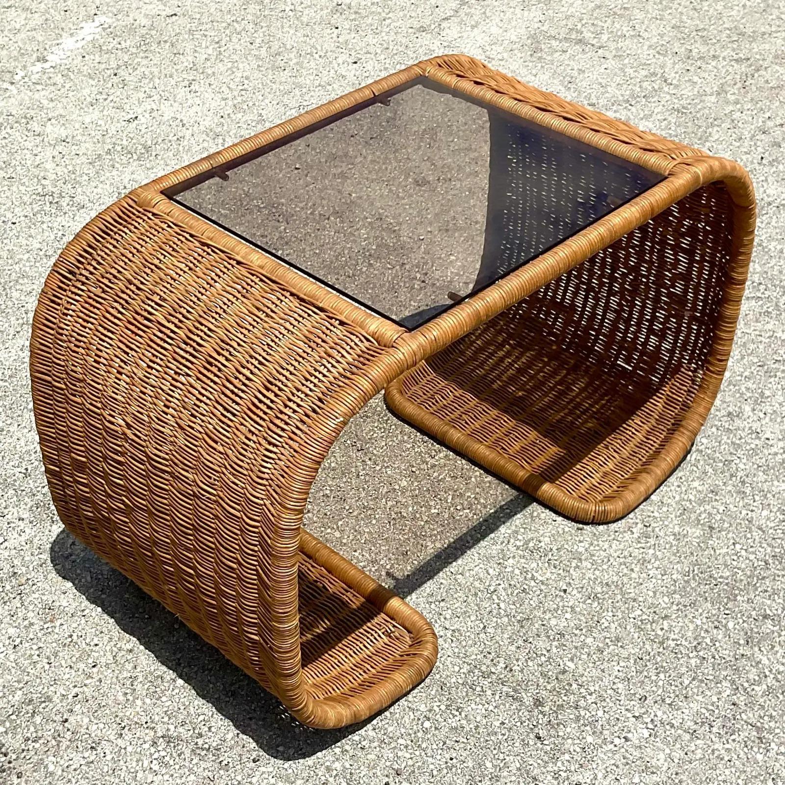 Vintage Coastal coffee table. Fabulous woven rattan in a chic waterfall shape. Inset glass panel on top. Acquired from a Palm Beach estate.