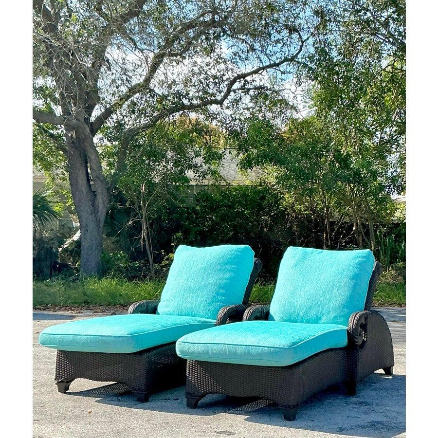 Porta relax ed eleganza nel tuo spazio all'aperto con questa coppia di chaise longue in rattan intrecciato vintage della costa. Progettate con una struttura in rattan intrecciato scuro e sormontate da vivaci cuscini turchesi, queste sedie a sdraio