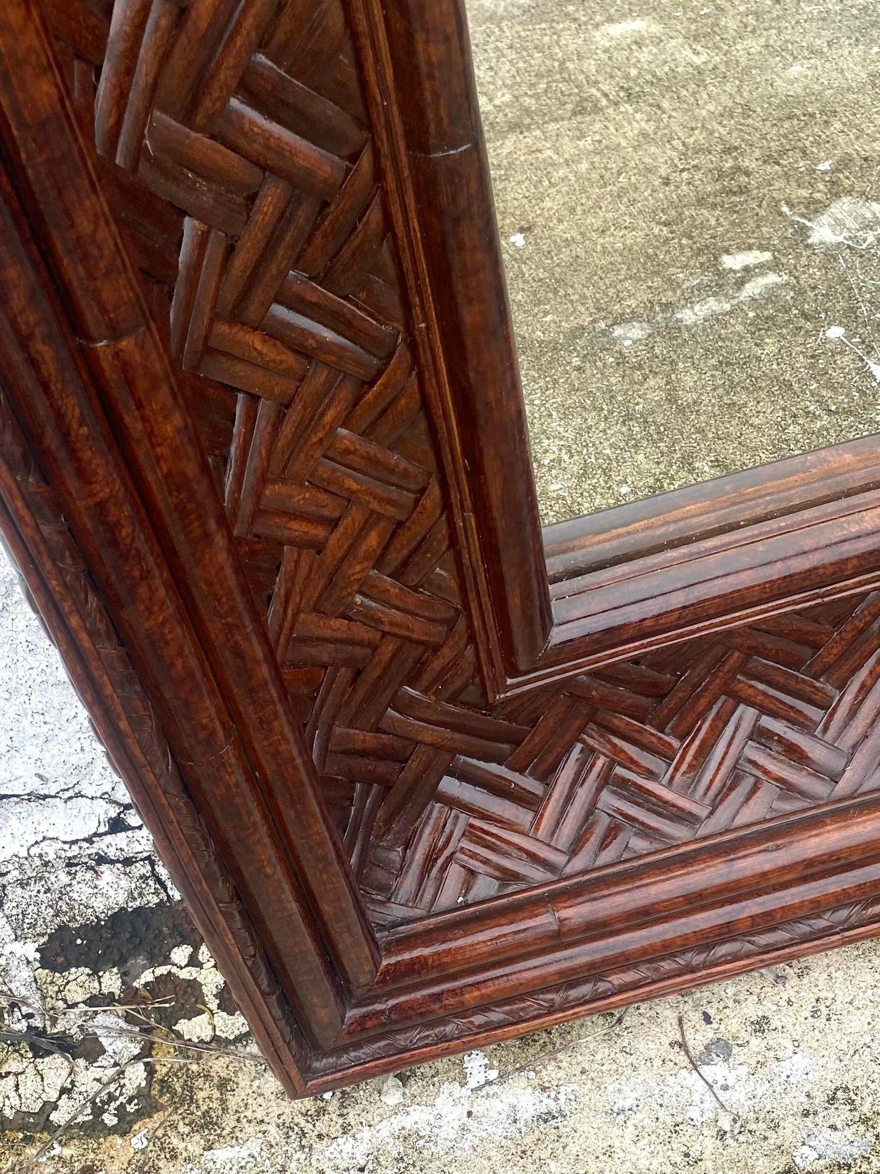 Magnifique miroir côtier vintage. Fabriqué à partir d'un magnifique motif de roseau fendu tissé, peint d'un brun profond. Un cadre lourd, beau et épais. Un ajout saisissant à n'importe quelle pièce. Acquis d'une propriété de Palm Beach.