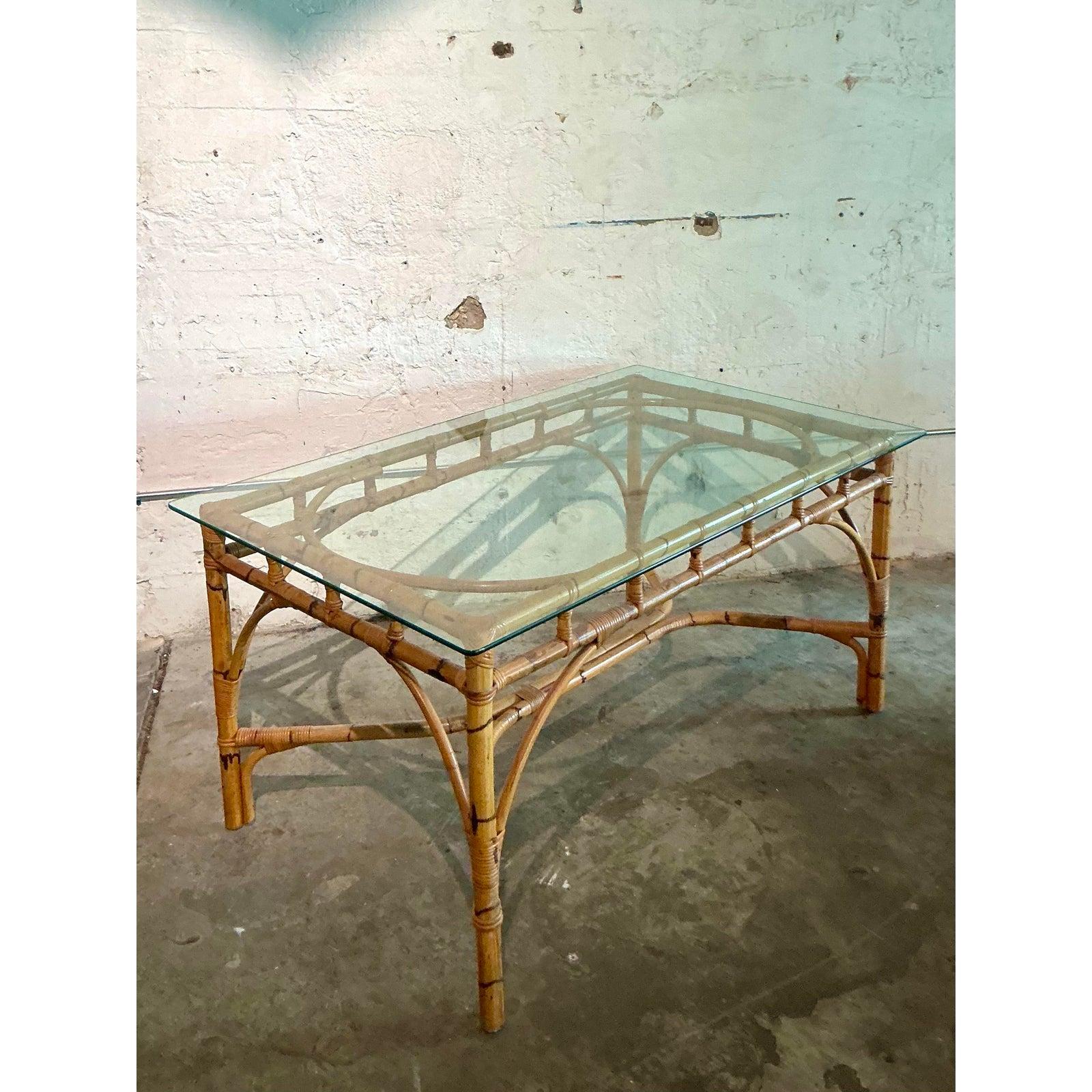 Introduce a touch of organic warmth and vintage charm to your home with this exceptional bamboo and glass dining table. The base is a masterpiece of craftsmanship, featuring a robust bamboo frame elegantly shaped into graceful arches and reinforced