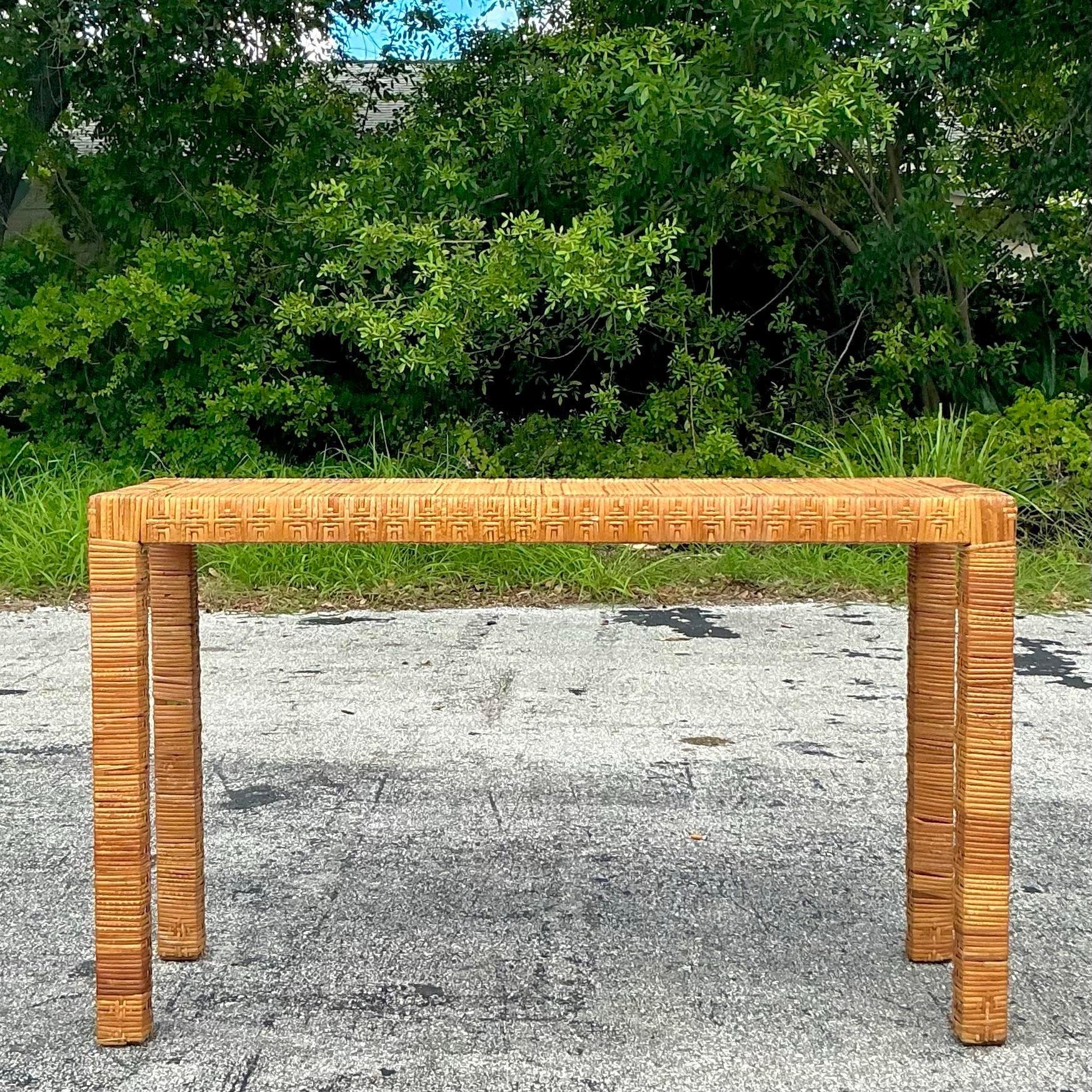 Enhance your home with the Vintage Coastal Wrapped Rattan Console Table After Bielecky Brothers. This elegant piece showcases expert craftsmanship with its wrapped rattan design, blending coastal charm with vintage sophistication to create a stylish