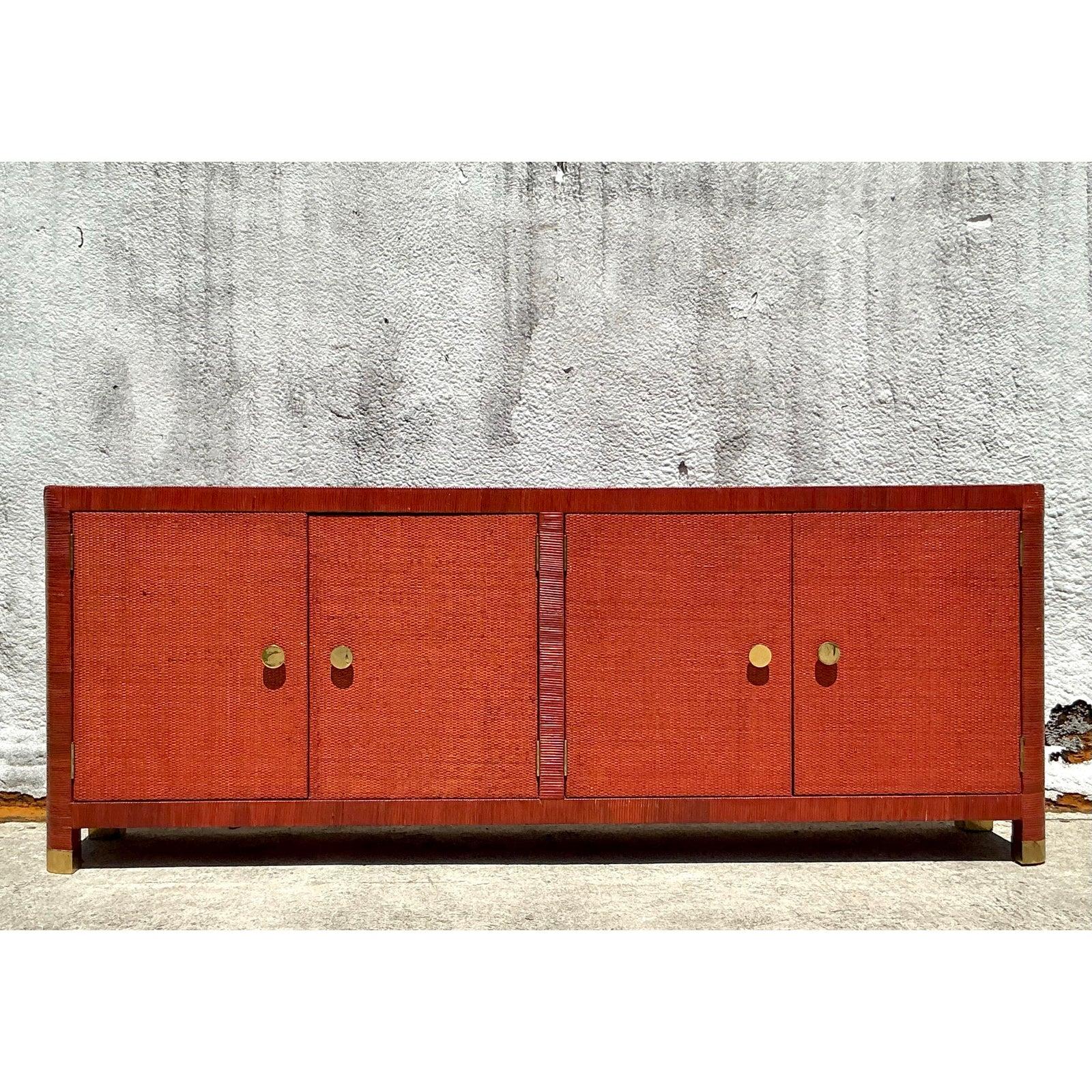 Infuse your home with unique texture and global sophistication with this exceptional Vintage Coastal Wrapped Rattan Credenza. This statement piece features a sleek silhouette fully encased in a rich, terracotta-toned woven material—likely raffia or